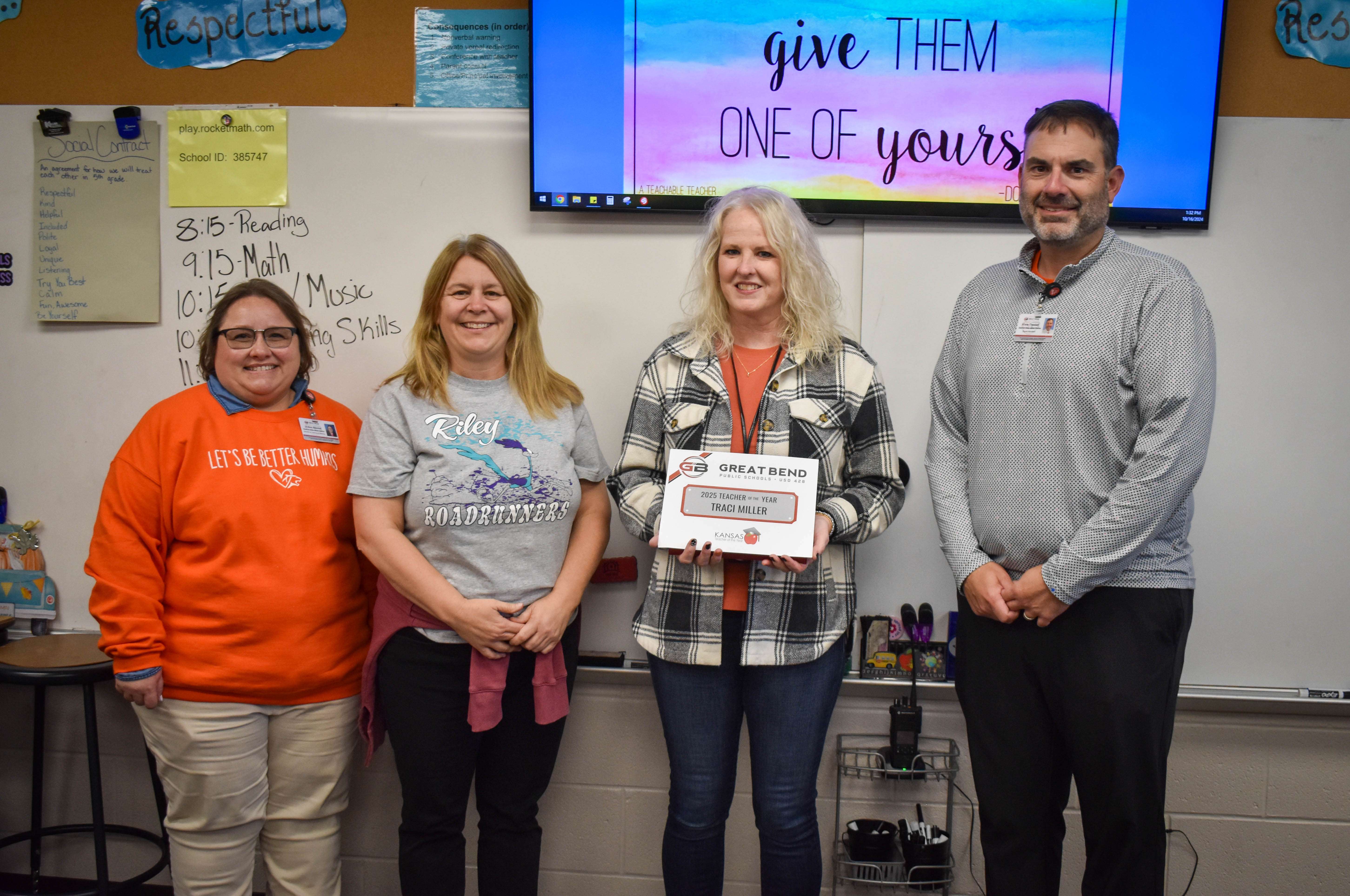 Surrounded by an audience of energetic fifth-grade students, Traci Miller, English Language Arts Instructional Coach at Riley Elementary School, was surprised with the 2025 USD 428 Elementary Teacher of the Year recognition on Wednesday, October 16, 2024. Miller has 28 years of teaching experience. Pictured left to right, JoAnn Blevins, USD 428 director of teaching and learning; Beth Rein, Riley principal; and Khris Thexton, USD 428 superintendent.
