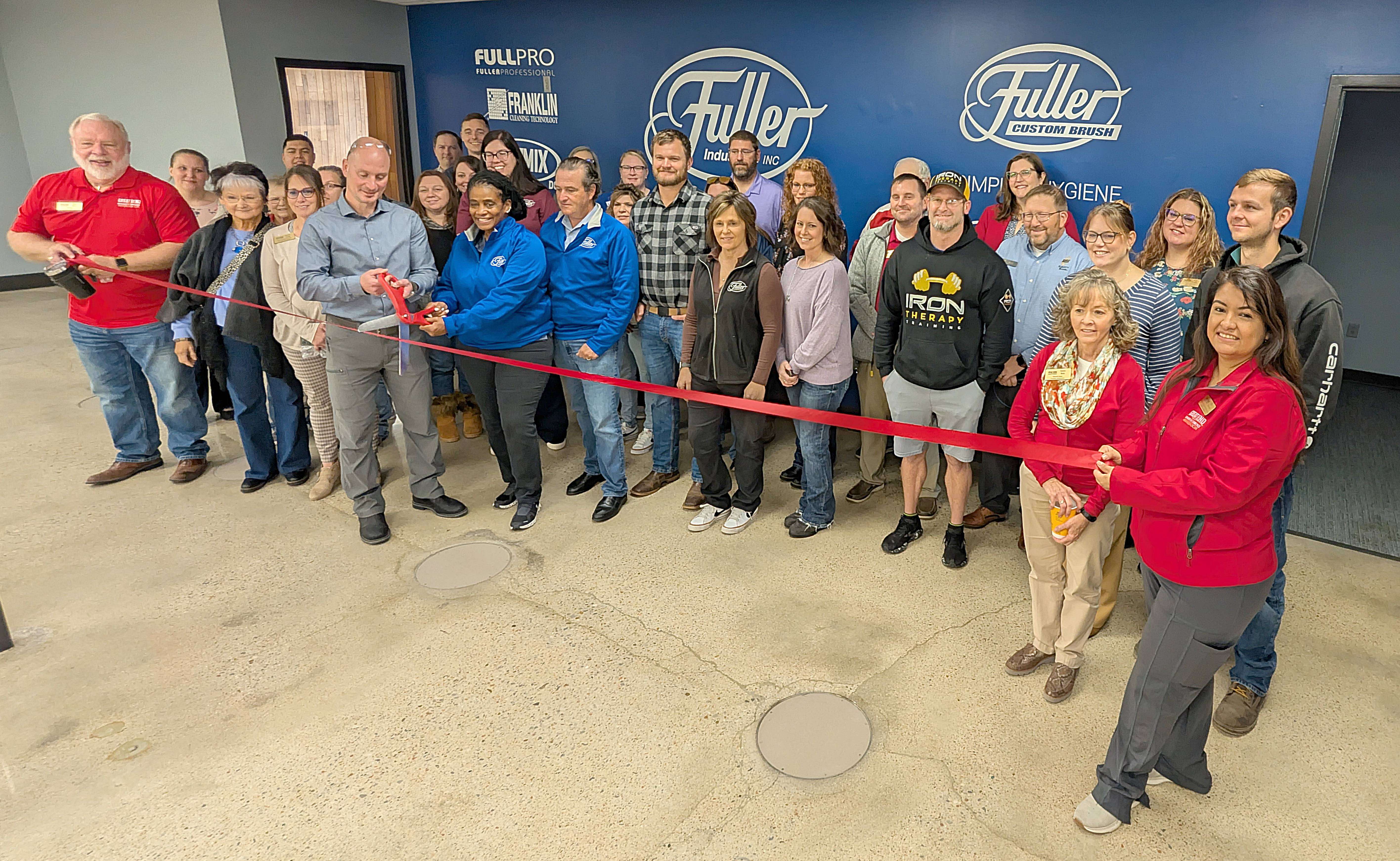 Fuller Industries Inc.’s Chief Executive Officer Craig Rudin joins Vice President and General Manager Joe Mann, center, fellow employees, Great Bend Chamber of Commerce ambassadors, and others to cut the ribbon following a Chamber coffee Thursday morning. Fuller is celebrating a recent expansion.