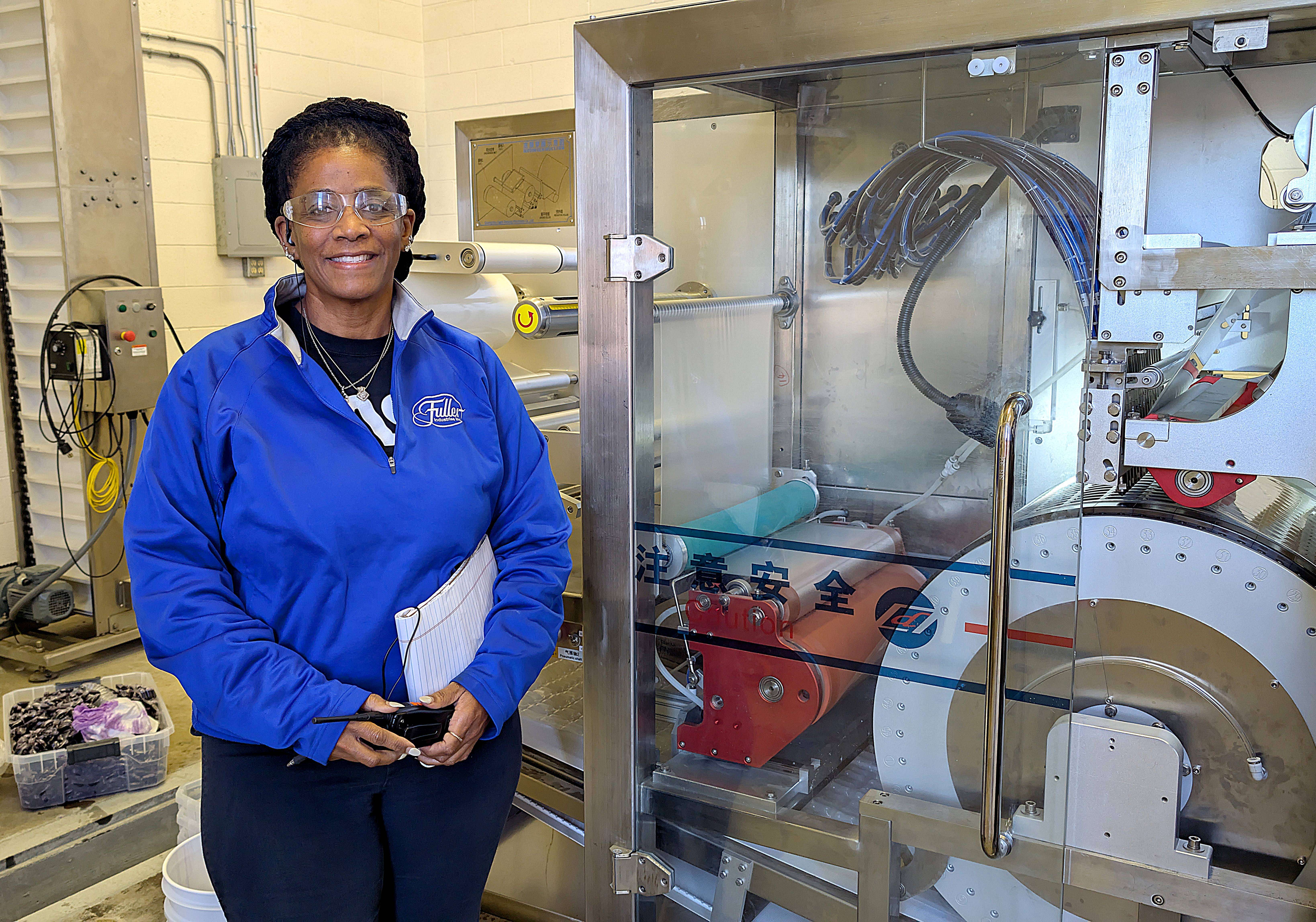Fuller Industries Inc.’s new Vice President of Operations Phyllis Jones, shown with one of the company’s newest pieces of high-tech equipment, has been on board for a month now after moving to Great Bend from the Dallas, Texas, area.