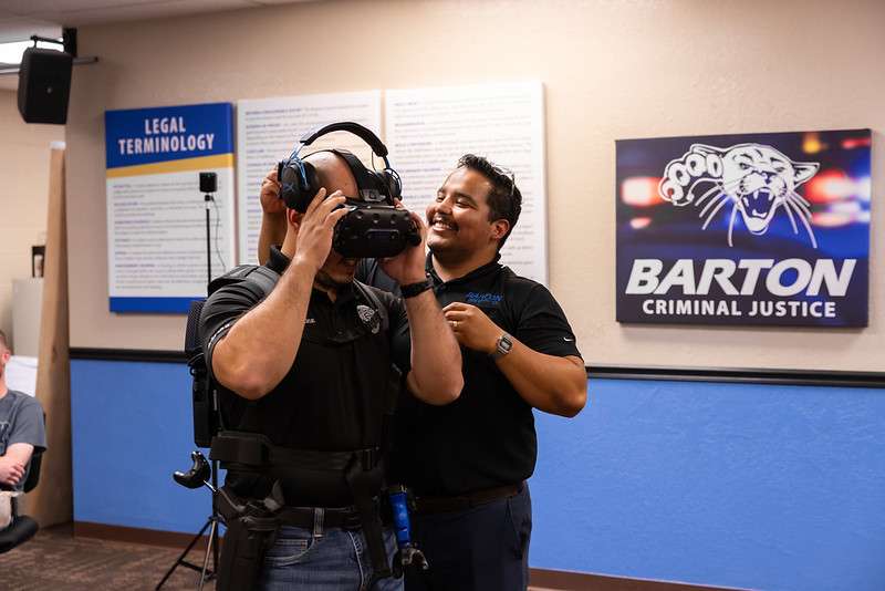 Barton instructor Christian Rivas gears up a Great Bend police officer for a simulation.