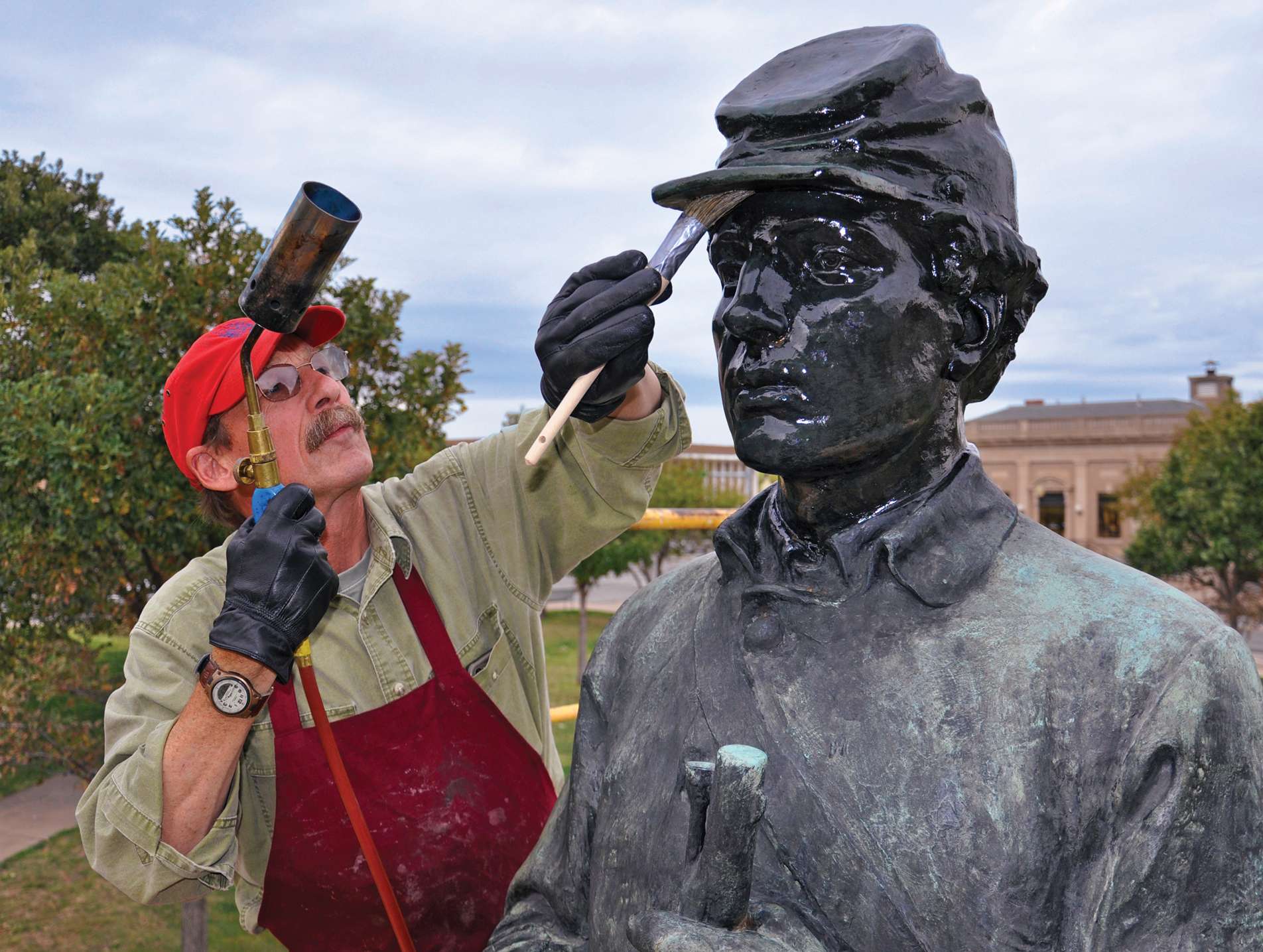 Ron Harvey, from Tuckerbrook Conservation, was hired to to clean and repair "The Rifleman" statue in Great Bend in 2015.
