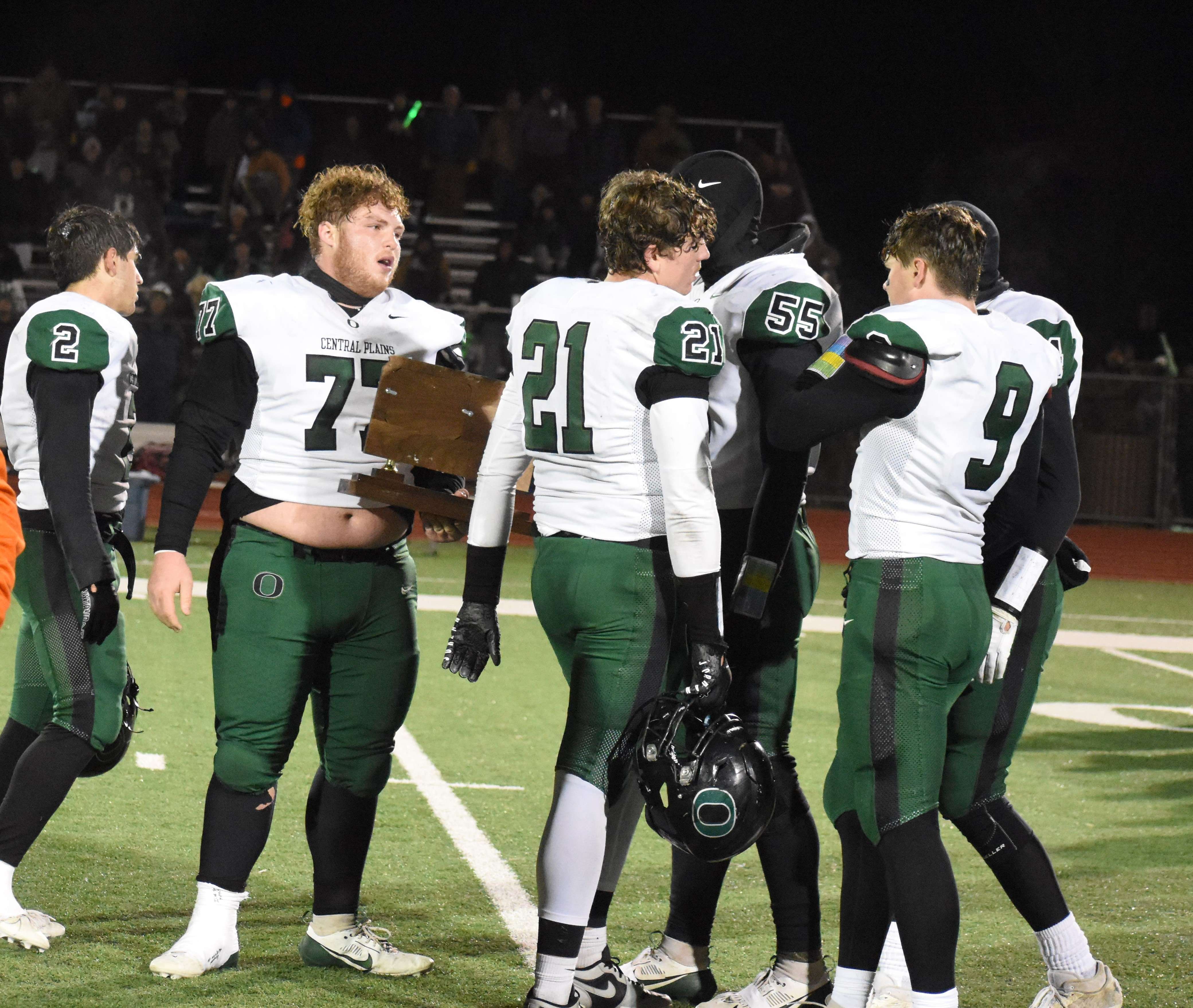 Central Plains senior Devin Davison (77) and teammates accept the state runner-up plaque Saturday evening in Greensburg following a 46-0 loss to Hoxie.