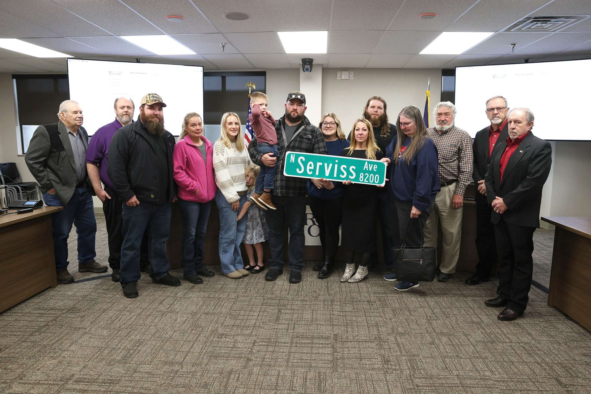 Members of the family of David Serviss receive a road sign of the section named in his honor at the Reno County Commission meeting December 23, 2024. Image Courtesy Reno County-Photo by Sandra Milburn.