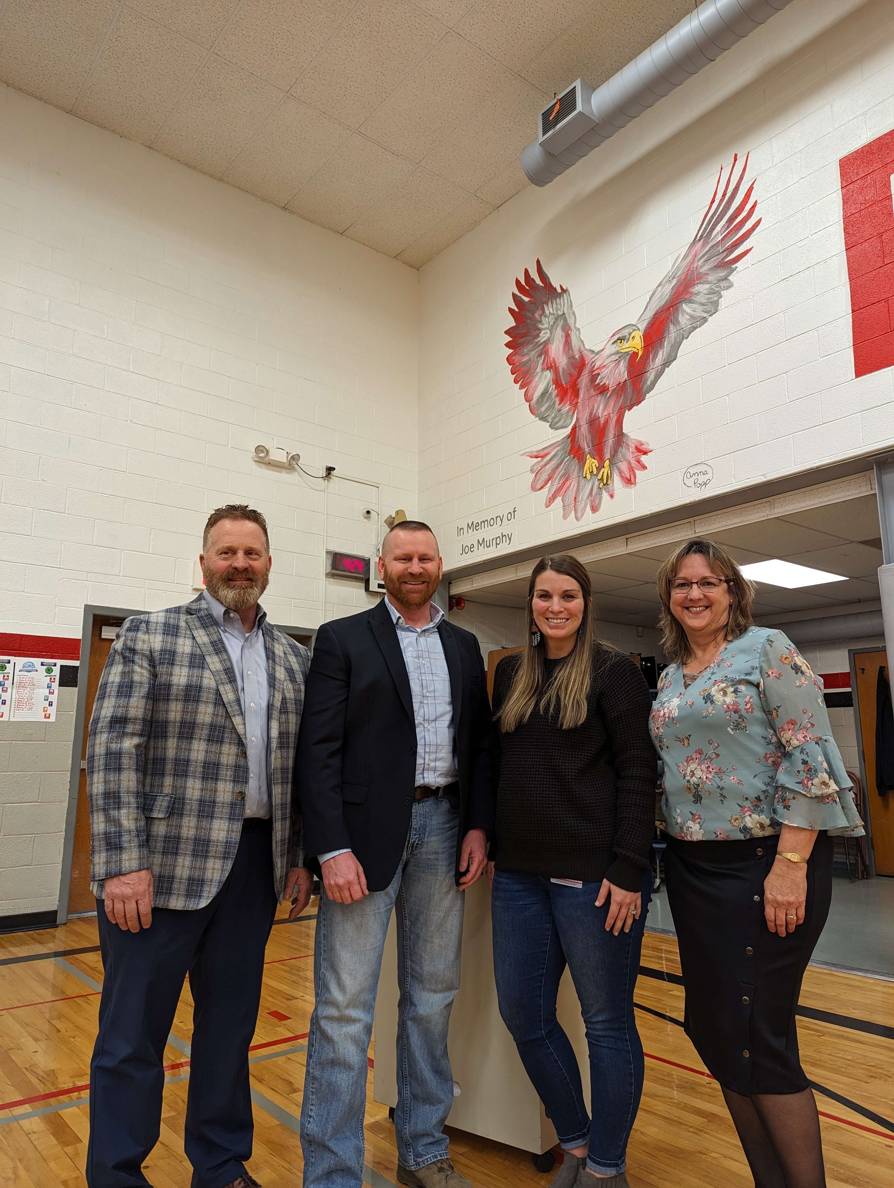 From left: Joe Murphy's sons, Patrick and Mark, with Eisenhower Principal Abby Jonas and former Eisenhower Principal Tricia Reiser. (event photos by Andrea Bauer/USD 428)