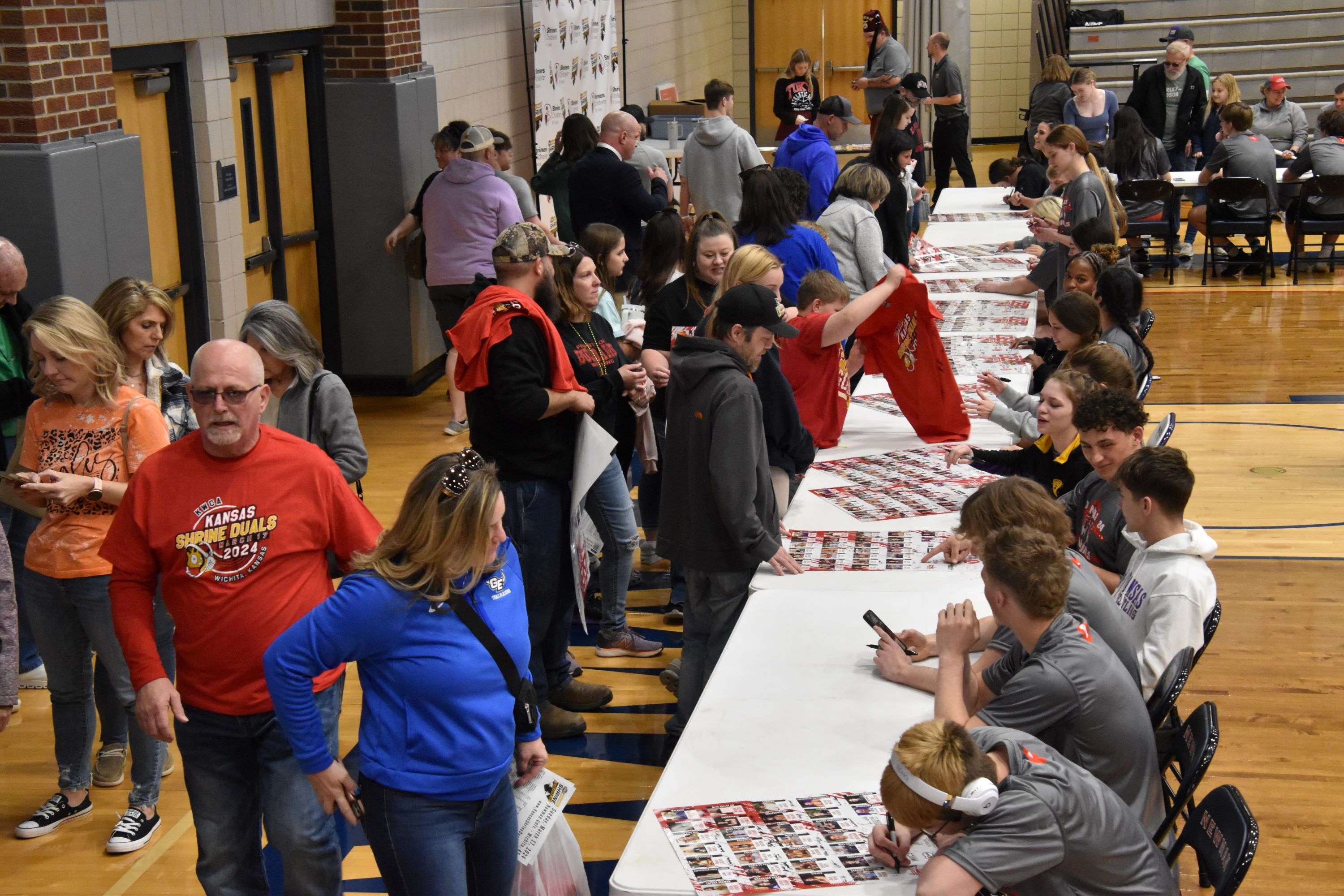 Wrestlers signing autographs for fans prior to the KWCA Kansas Shrine Duals