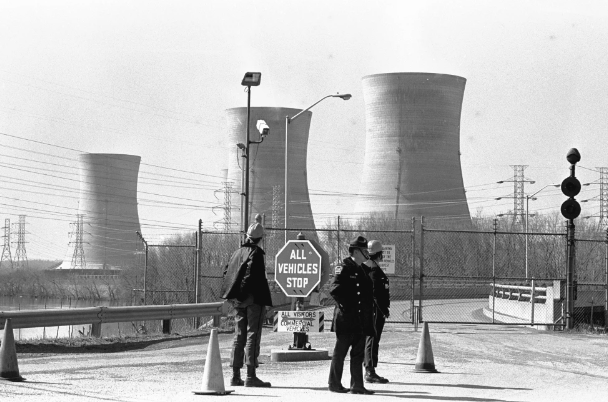 FILE - In this undated file photo, a Pennsylvania state police officer and plant security guards stand outside the closed front gate to the Metropolitan Edison nuclear power plant on Three Mile Island near Harrisburg, Pa., after the plant was shut down following a partial meltdown on March 28, 1979. Friday, March 28, 2014 marks the 35th anniversary of the partial core meltdown at the nuclear power plant. (AP Photo/Paul Vathis, File)