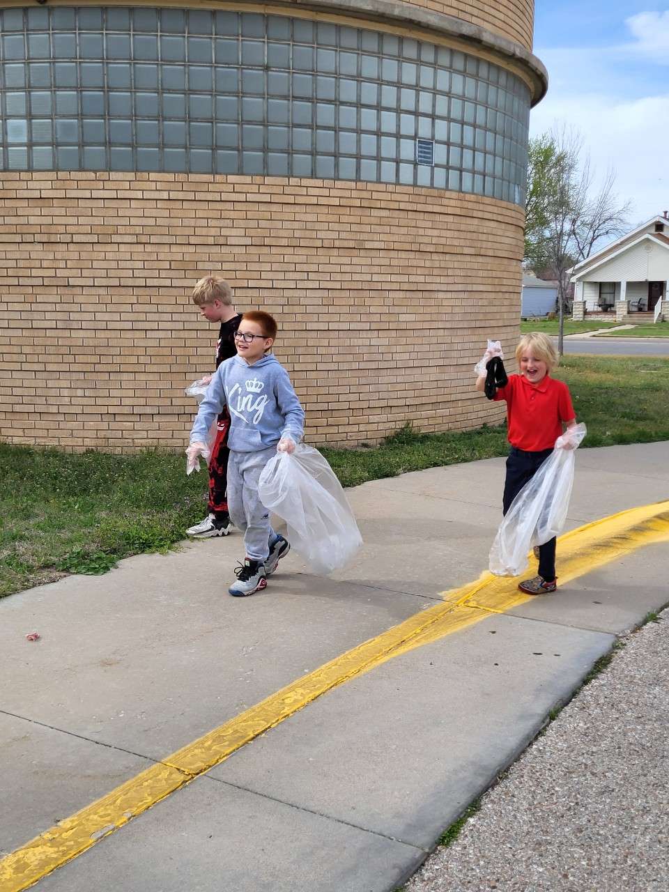 Boys and Girls Club members pick up trash around their site.