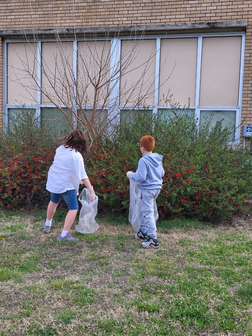 Boys and Girls Club members pick up trash around their site at Avenue A school.