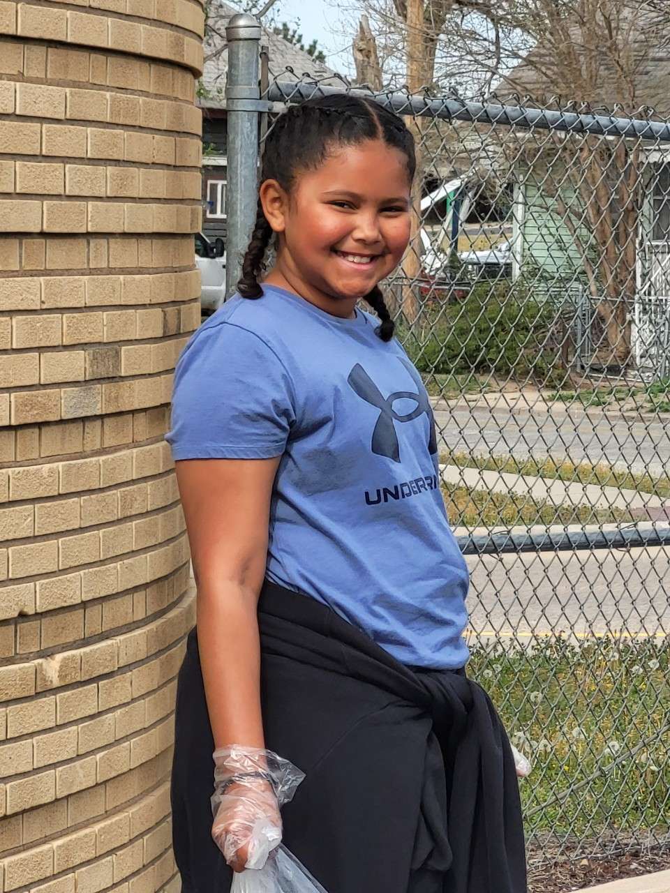 Boys and Girls Club members work to pick up trash around their site at Avenue A school.