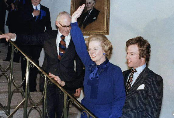 Mrs. Thatcher shown with her son, Mark, As she gives a jubilation wave at her Party HQ. (AP PHOTO)