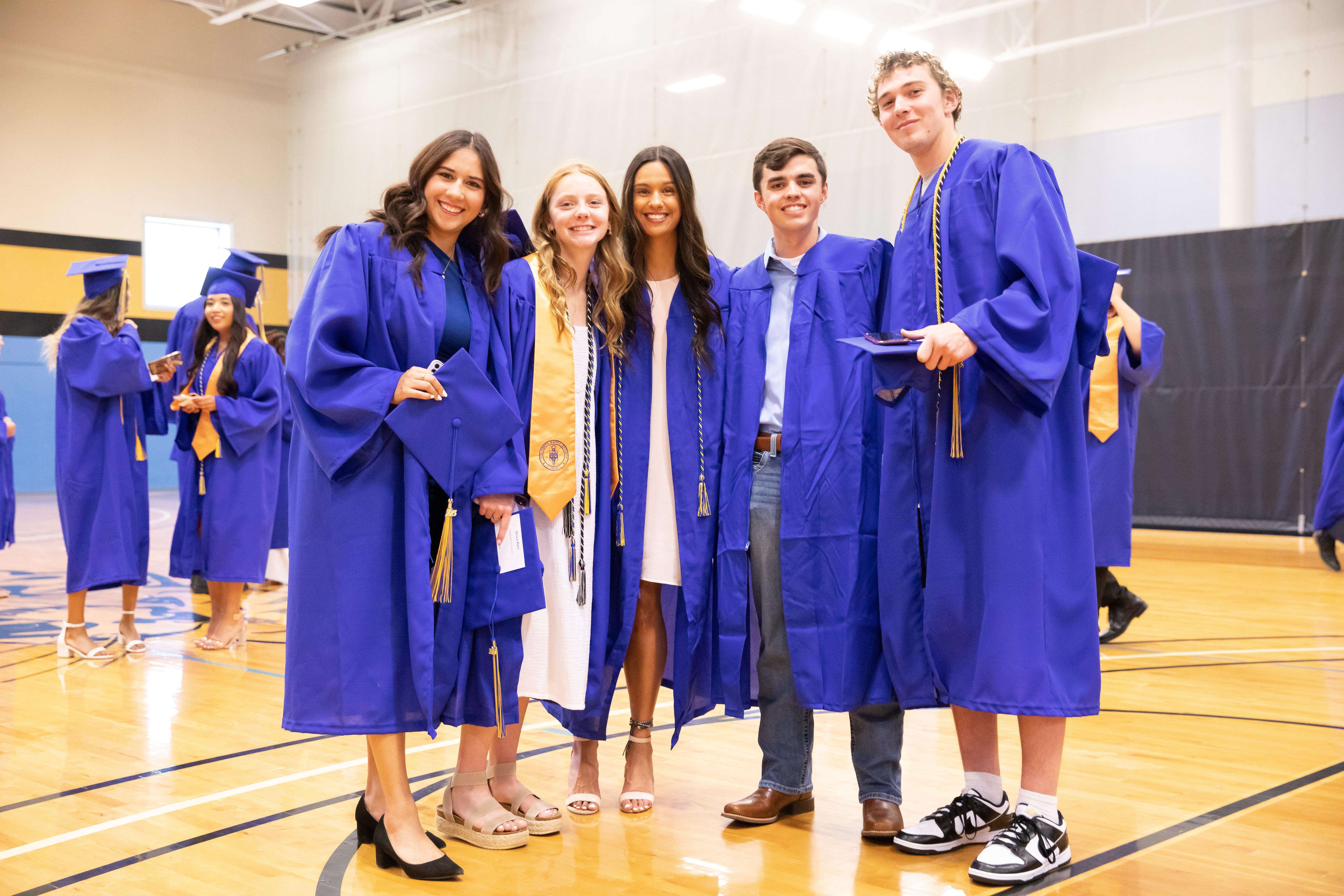 Students pause for a photo before the 2023 commencement ceremony in the Barton Gym.