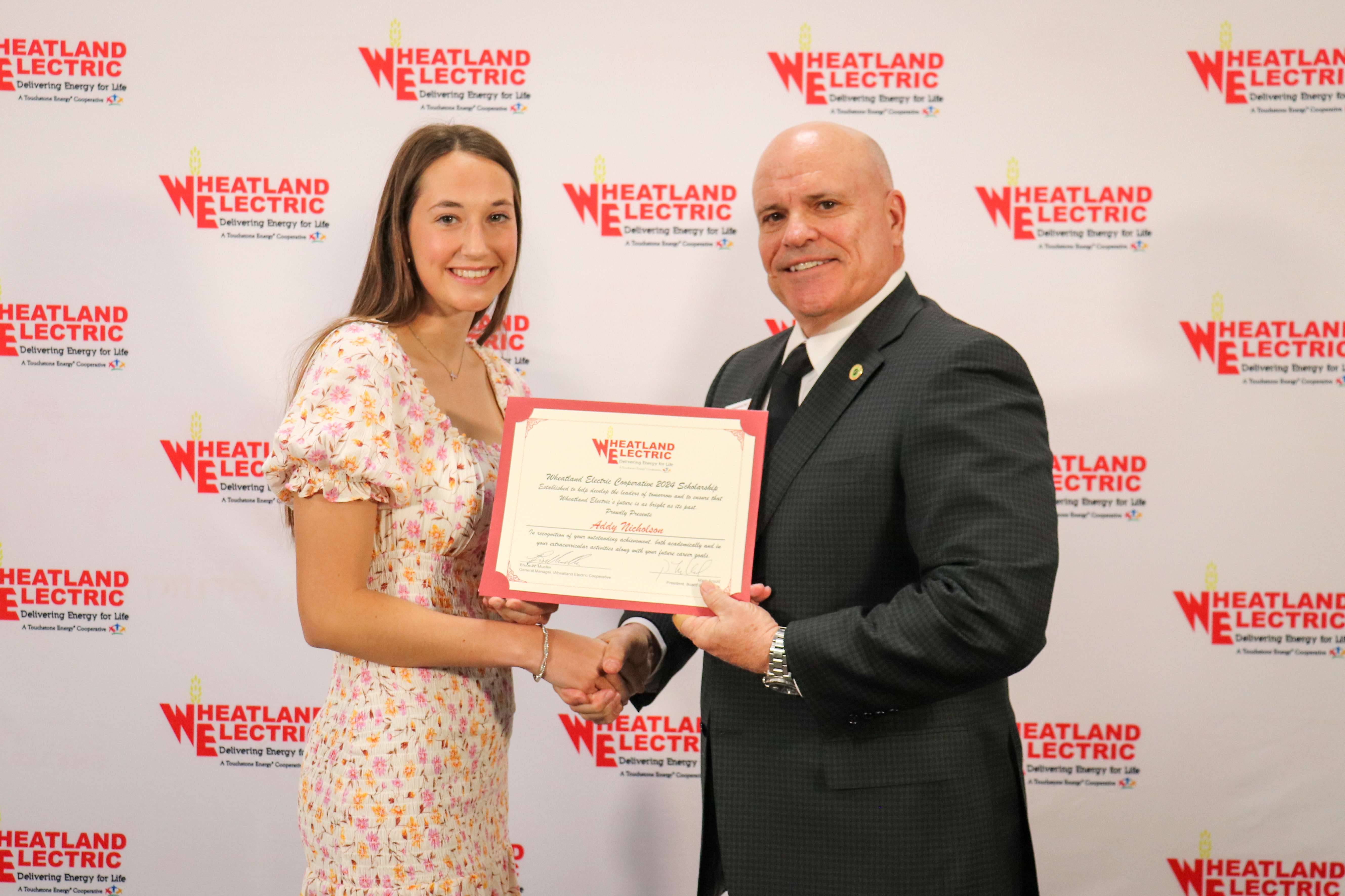 Bruce W. Mueller (right), CEO/general manager of Wheatland Electric Cooperative, Inc., awards Addy Nicholson (left), senior at Great Bend High School, with a $1,000 scholarship during WEC’s annual meeting in Great Bend on April 24.