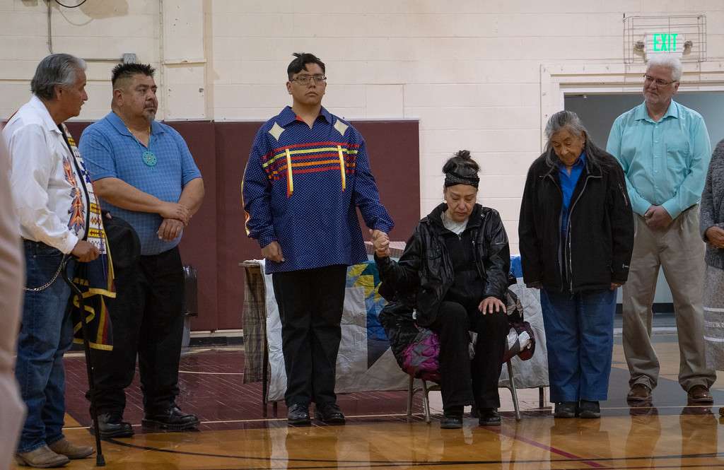 Family members and friends of Chadron State College graduating senior Vernon Plenty Bull of Allen, S.D., center. From left, Steve Dubray, medicine man and uncle of Plenty Bull, left, explains the eagle feather-tying ceremony. From left, Pete Plenty Bull, father, Mary Plenty Bull, mother, Agnes Plenty Bull, grandmother, and Mark Hunt, CSC Security Supervisor and Plenty Bull's work supervisor, right, April 28, in Armstrong Gymnasium. (Photo by Tena L. Cook/Chadron State College)