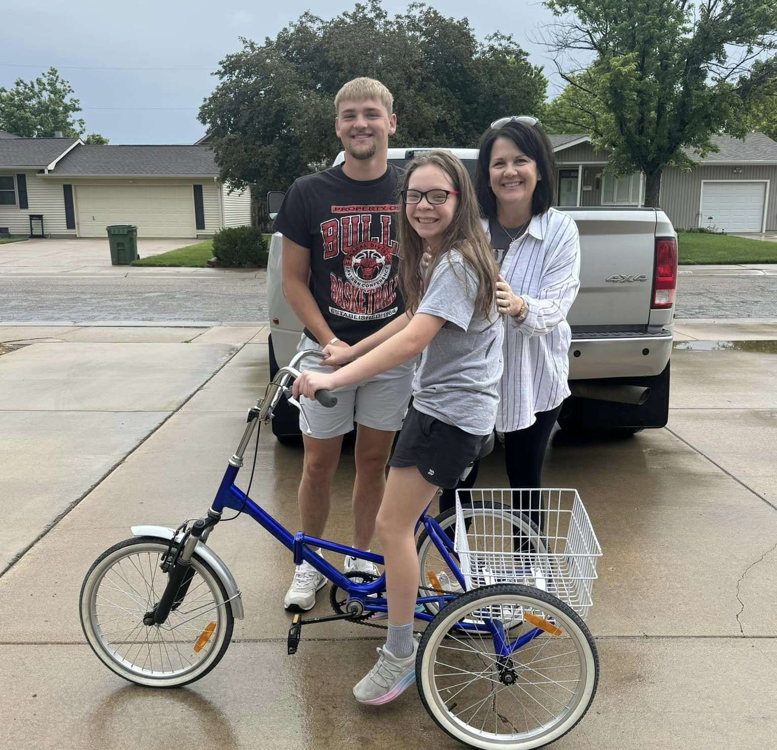 Gentry Ramsey with Colton and Jeana Brack, and her stolen trike that was found and returned by the Bracks.