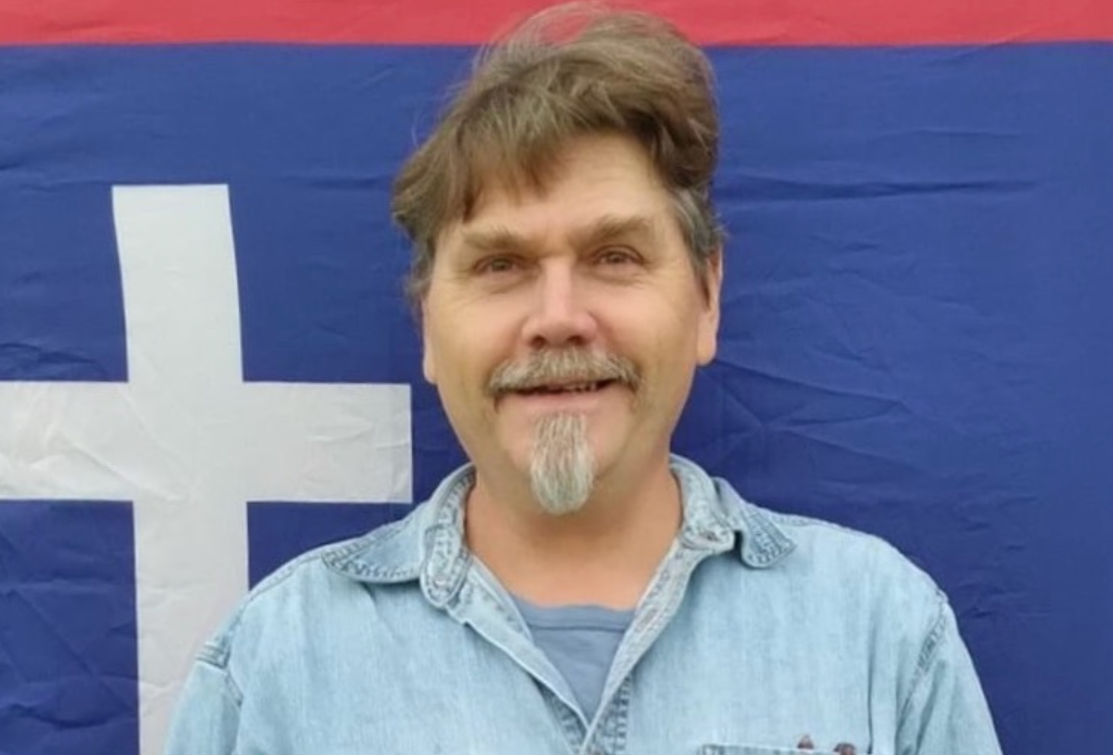 Darrell McClanahan of Milo, a candidate for governor who the Missouri Republican Party attempted to remove from the ballot for being an ‘honorary’ KKK member. He is shown in a photo from his 2022 campaign for U.S. Senate, standing in front of the flag of the Missouri State Guard, a military force formed in 1861 to oppose the Union in the Civil War (Campaign photo).
