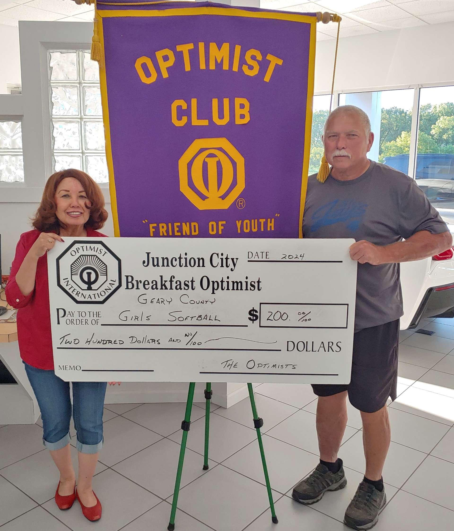 Pictured left to right are Nita Miller, JC Breakfast Optimist Club President and Jeff Childs, President of the Geary County Girls Softball.&nbsp;