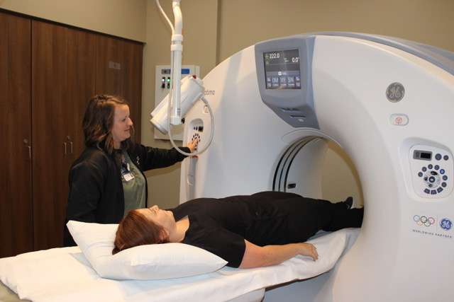 Julie Robben, standing, demonstrates the CT scan procedure at Pawnee Valley Community Hospital’s Imaging Department with the help of Kelsey King, staff member. Robben is Director of Imaging.