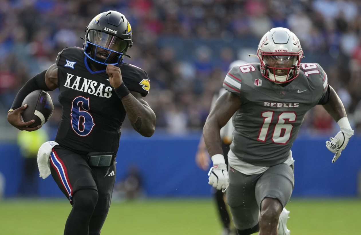 Kansas quarterback Jalon Daniels (6) runs for a touchdown against UNLV linebacker Mani Powell (16) in the first half of an NCAA college football game Friday, Sept. 13, 2024, at Children's Mercy Park in Kansas City, Kan.