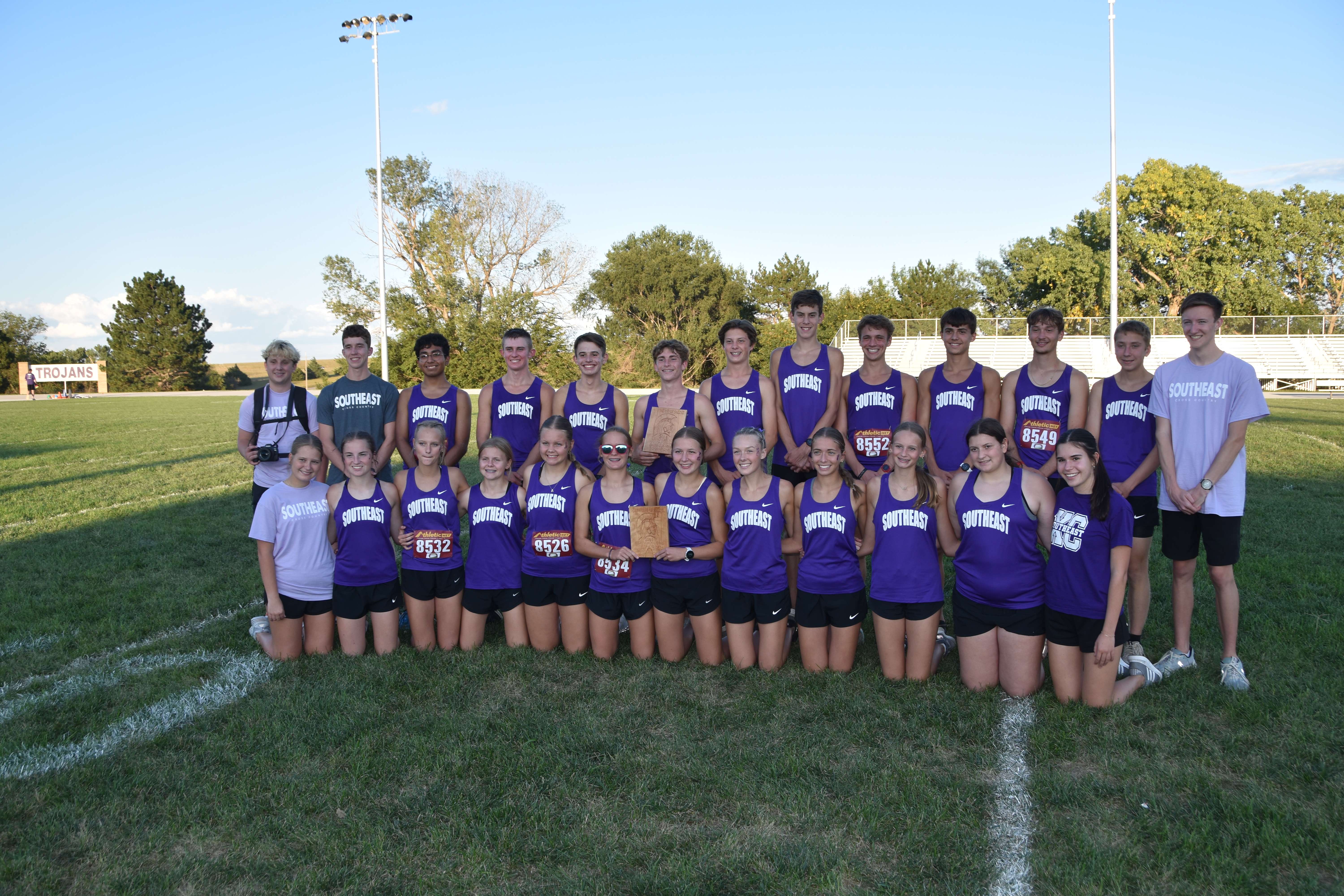 The SES boys and girls cross country teams show off the hardware after a dominant home performance.