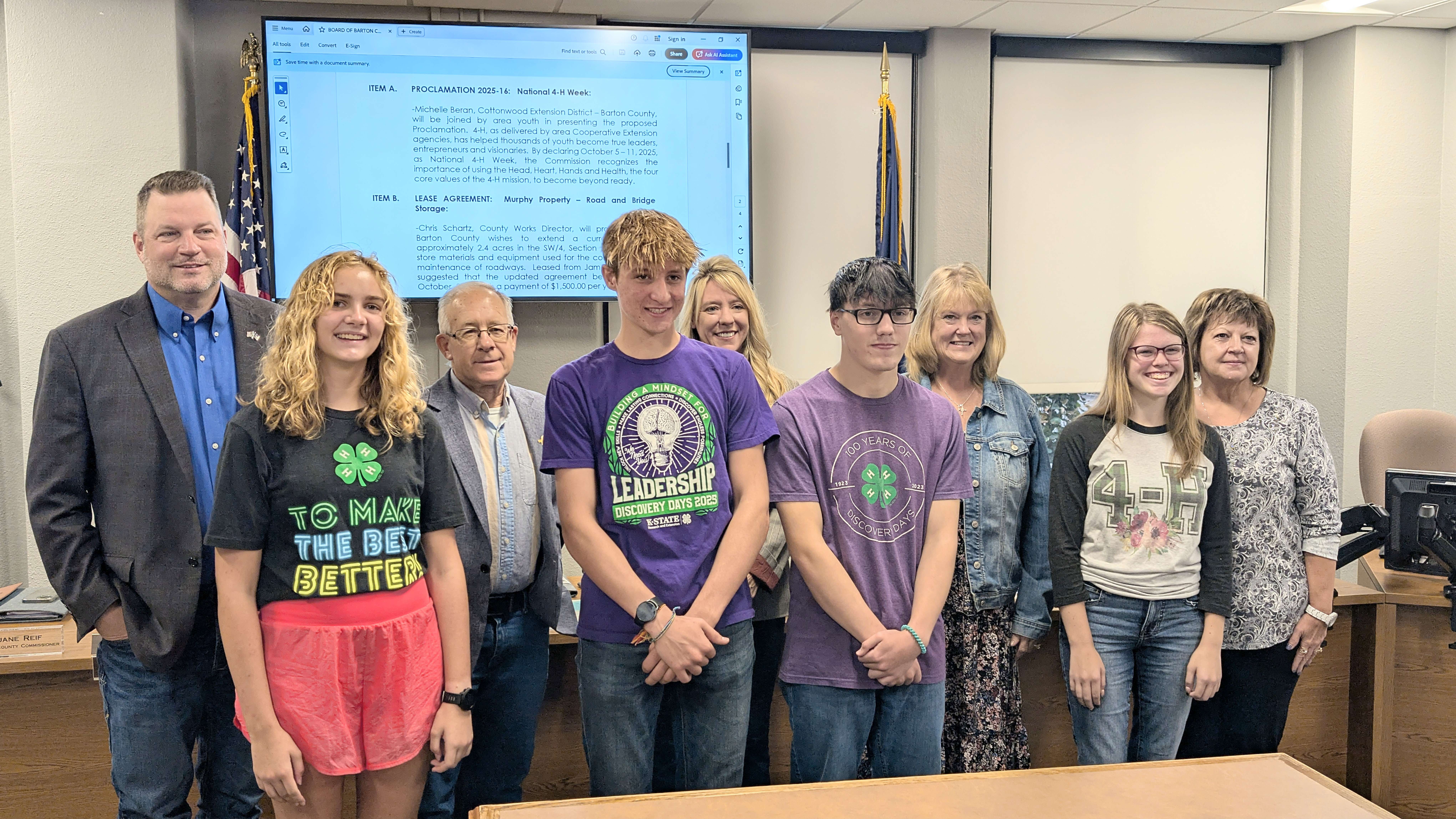 Barton County commissioners Shawn Hutchinson, Duane Reif, Tricia Schlessiger, Barb Esfeld and Donna Zimmerman, in the back row, show their support for Barton County 4-Hers Samantha Negaard, Russell Kern, D.J. Wyant and Melody Braddy during the Commission meeting Tuesday morning. The Commission had just adopted a proclamation marking next week as National 4-H Week.