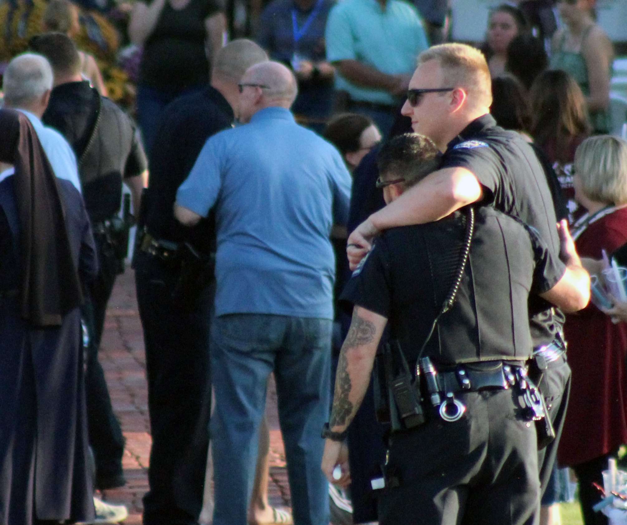 Officers console each other at a vigil for Hays Police Sgt. Scott Heimann, who was killed in the line of duty on Sunday. Photo by Cristina Janney/Hays Post
