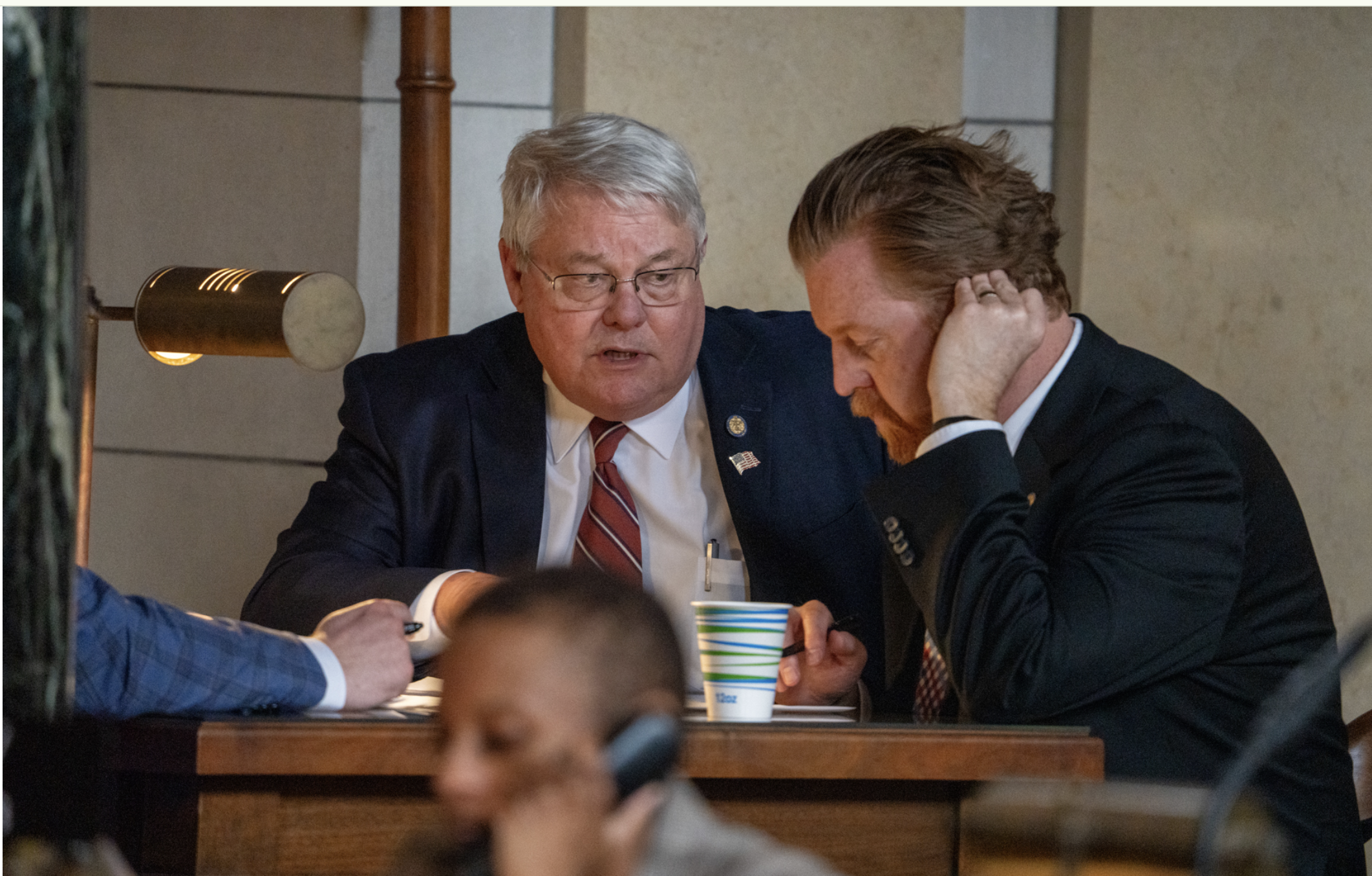  State Sens. Rick Holdcroft of Bellevue and John Cavanaugh of Omaha, chair and vice chair of the Legislature’s General Affairs Committee, from left, meet off the legislative floor. April 8, 2025. (Zach Wendling/Nebraska Examiner)