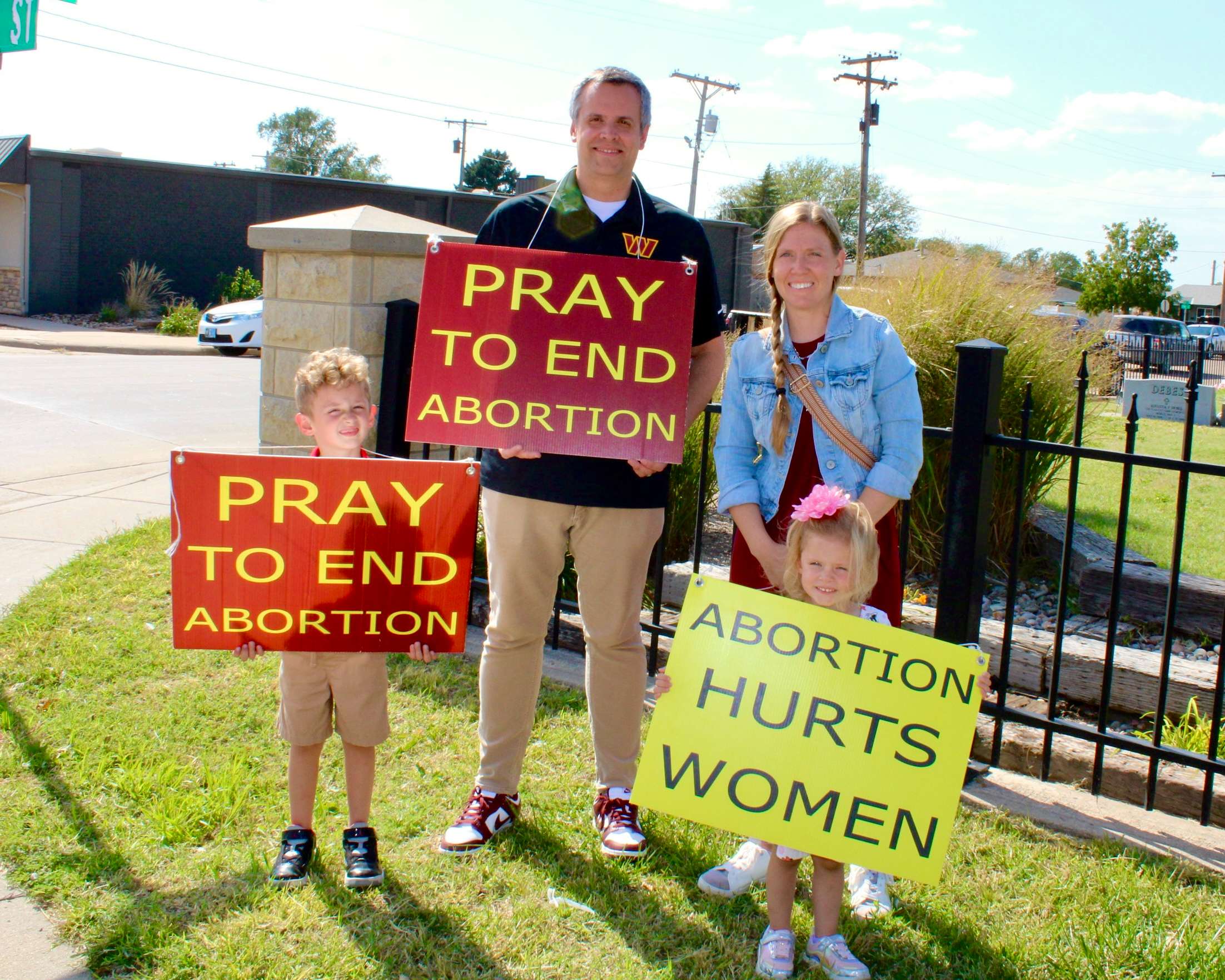 A family holding pro-life signs on Vine Street for the 2025 National Life Chain. Photo by Tony Guerrero/Hays Post
