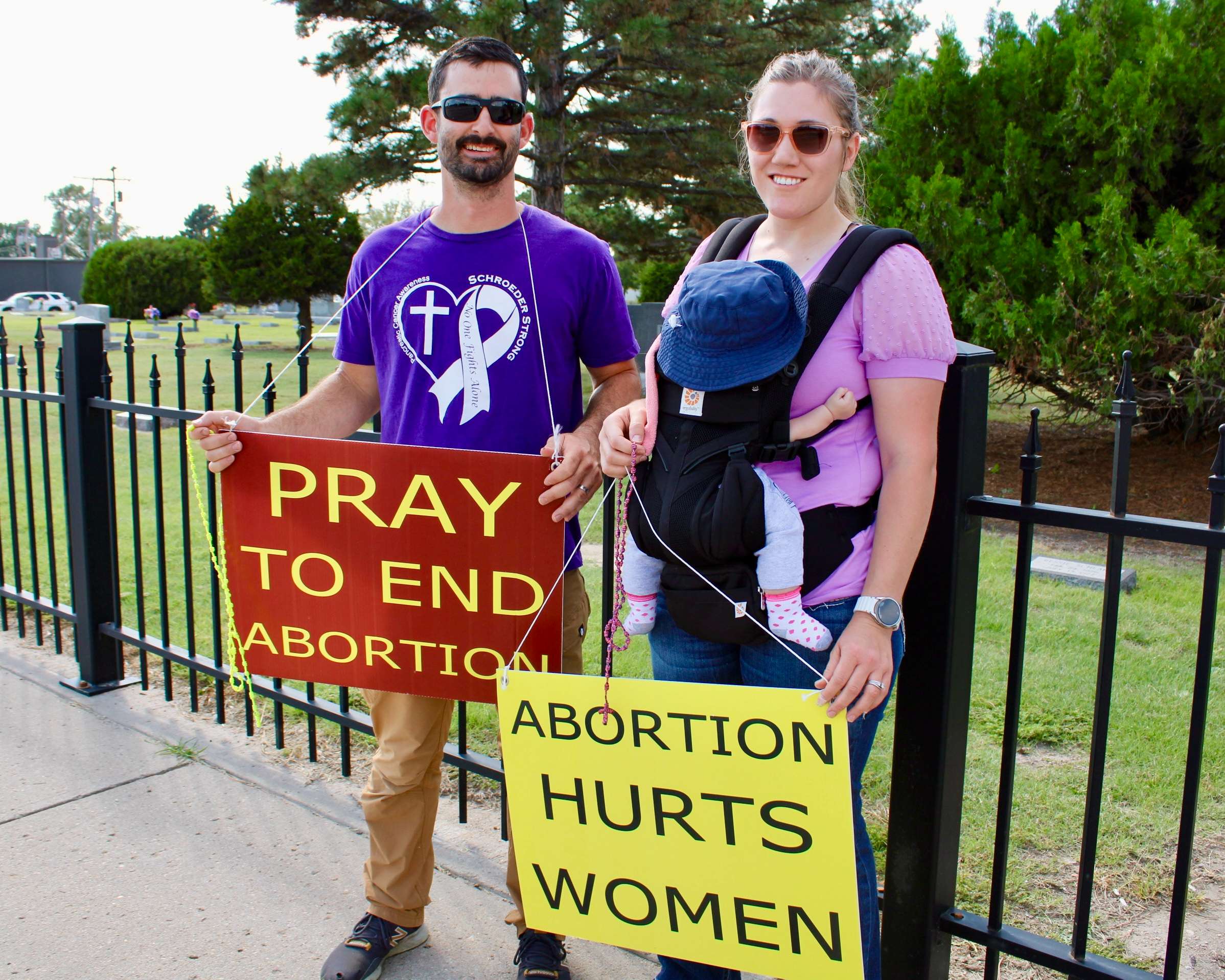 Chase Berg and Julie Berg holding pro-life signs with their baby on Vine Street for the 2025 National Life Chain. Photo by Tony Guerrero/Hays Post