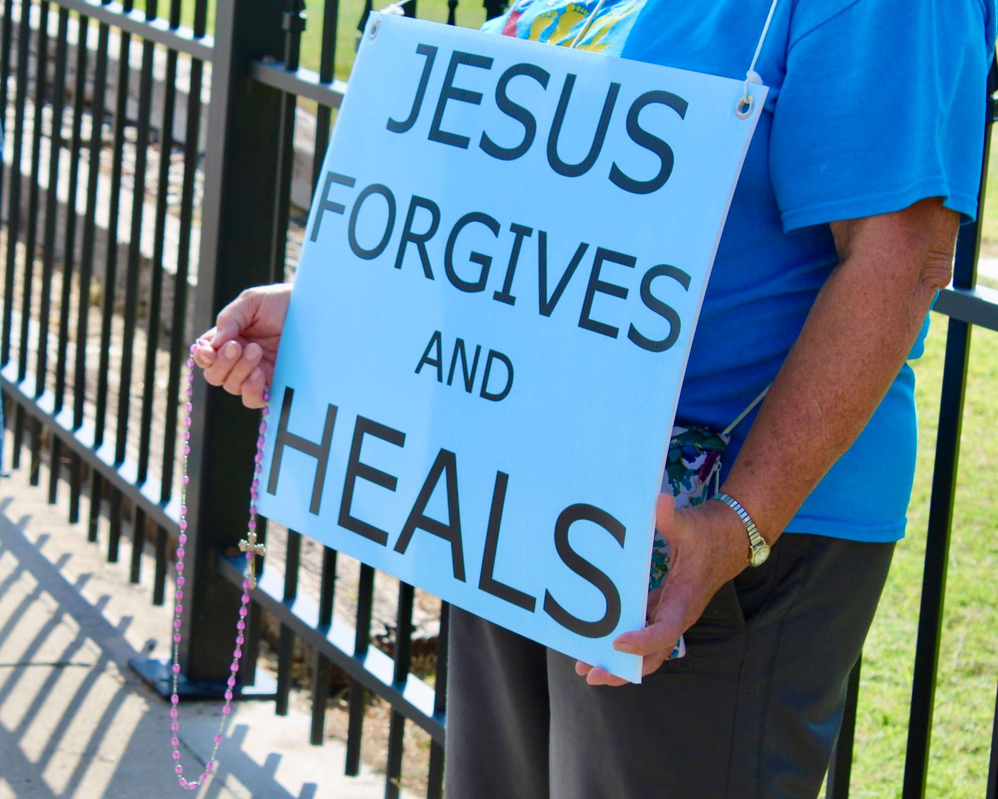 An attendee with a pro-life sign and rosary. Photo by Tony Guerrero/Hays Post