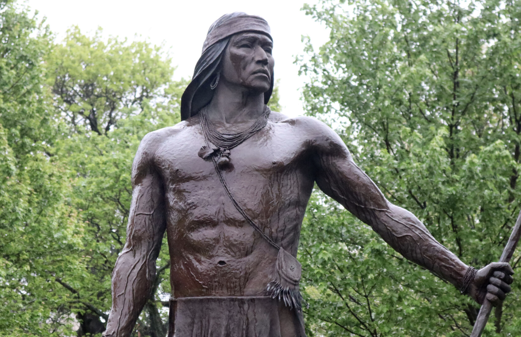 The University of Kansas and Haskell Indian Nations University is collaborating with tribes and schools on a $1.5 million, five-year program to educate and support 15 teachers who would be obligated to teach in Native-serving schools. This image is of a statue on the HINU campus in Lawrence, Kansas, depicting an Apache hoop and pole game player. (Max McCoy/Kansas Reflector)