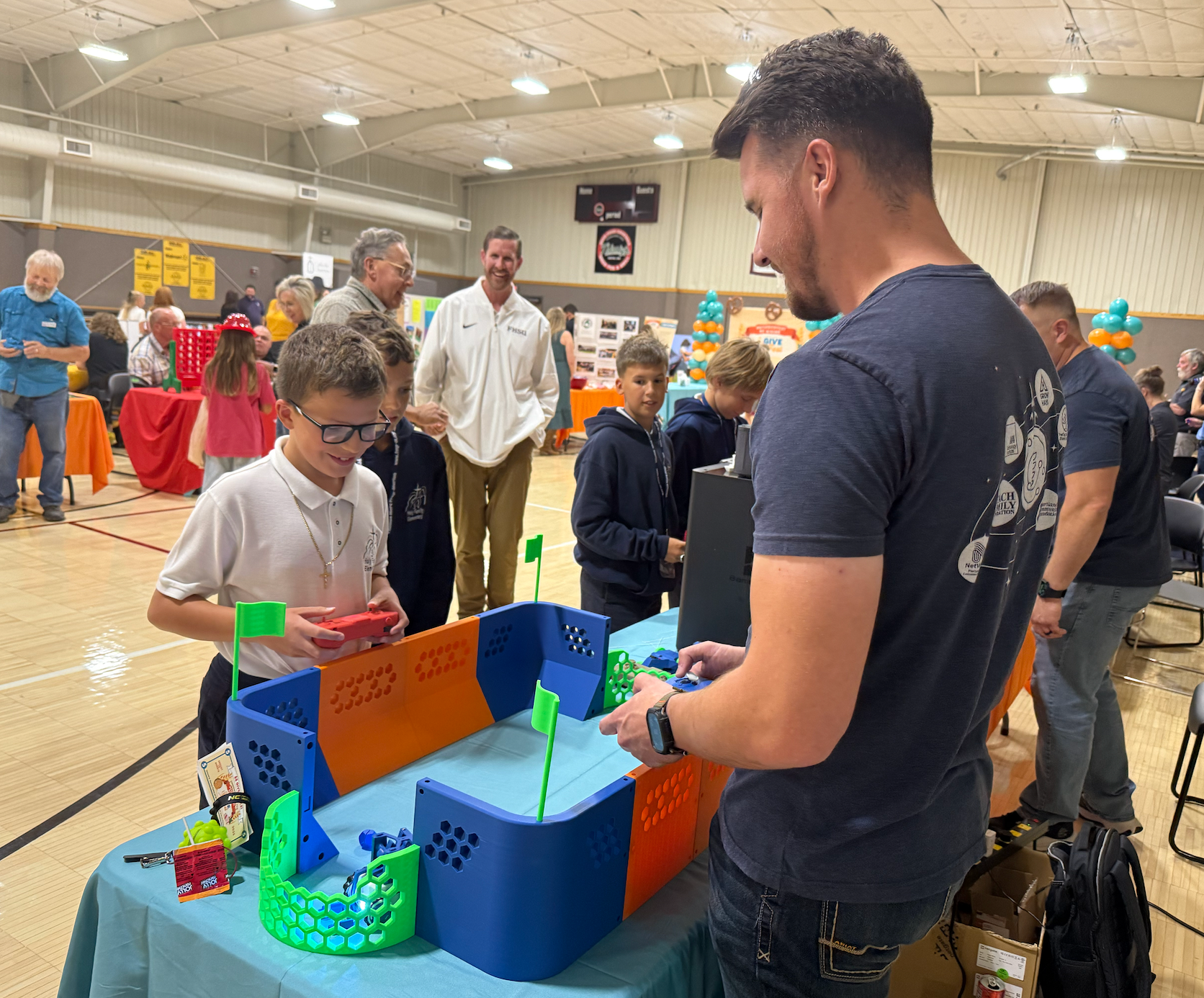A volunteer from STEM Harvest of Hays engages in a robot battle with a student from Holy Family Elementary School during the Heartland Community Foundation Give Fest on Friday. Photo by Cristina Janney/Hays Post