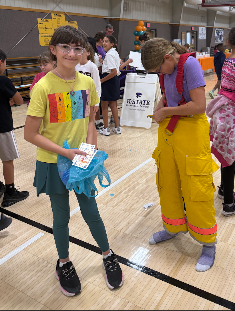 Hays USD 489 students try on fire gear at the Heartland Community Foundation Give Fest Friday at the Hays Recreation Center. Photo by Cristina Janney/Hays Post