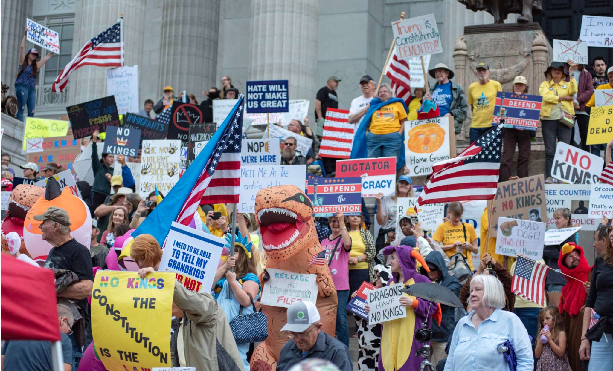 Protestors wave signs as thunder begins to rumble near the end of the No Kings demonstration at the Missouri State Capitol in Jefferson City on Saturday (Annelise Hanshaw/Missouri Independent).
