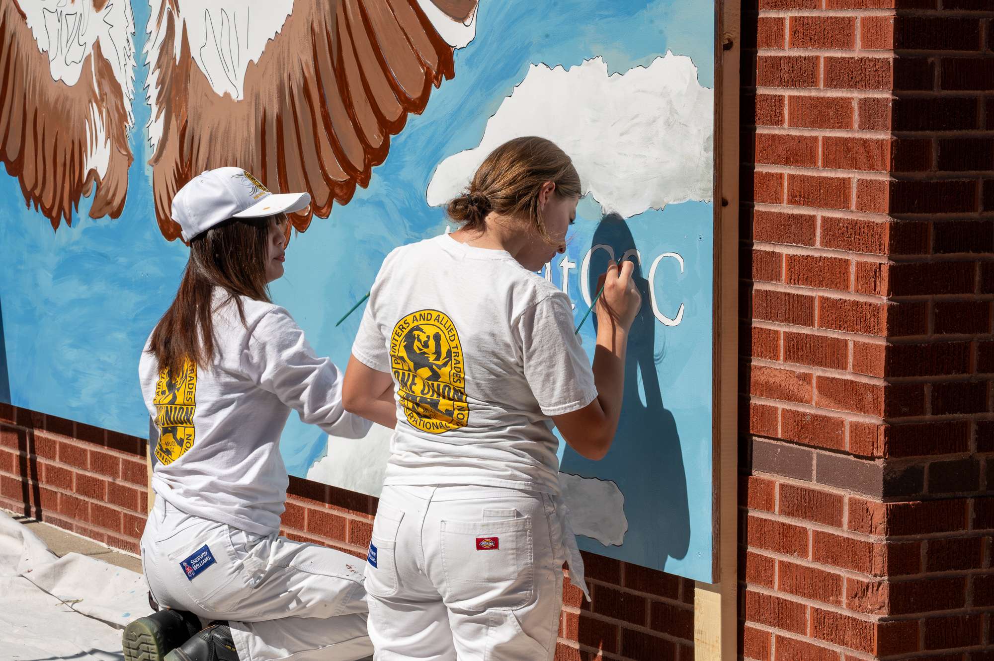 Volunteers assist with a mural on the South wall of the Student Center, Sept. 26, 2025. (Photo by Sydney Brown/Chadron State College)