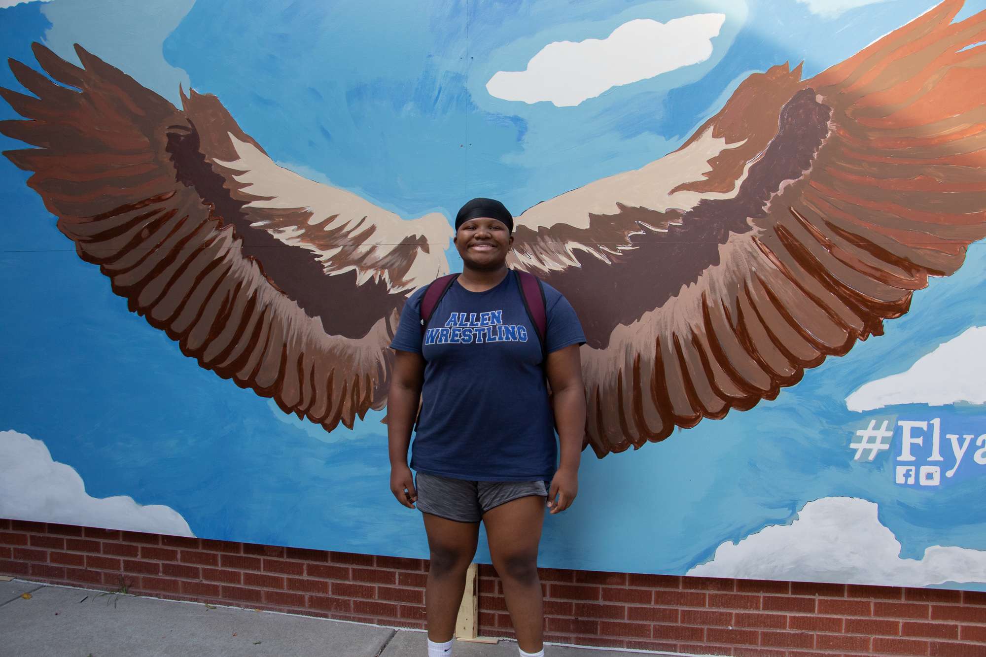 Chadron State College student Esther Peters poses with a new mural on the south side of CSC Student Center Sept. 26, 2025. (Photo by Tena L. Cook/Chadron State College)
