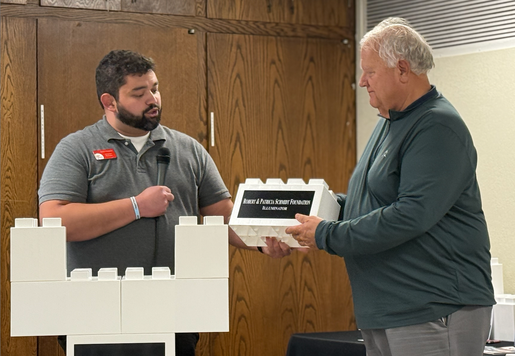 James Gerstner, High Plains development director, hands a donor block to Joe Jeter, trustee of the Robert and Patricia Schmidt Foundation, in honor of the foundation's $500,000 donation to the Crisis Intervention Center. High Plains still needs to raise $2.5 million more for the project. Photo by Cristina Janney/Hays Post