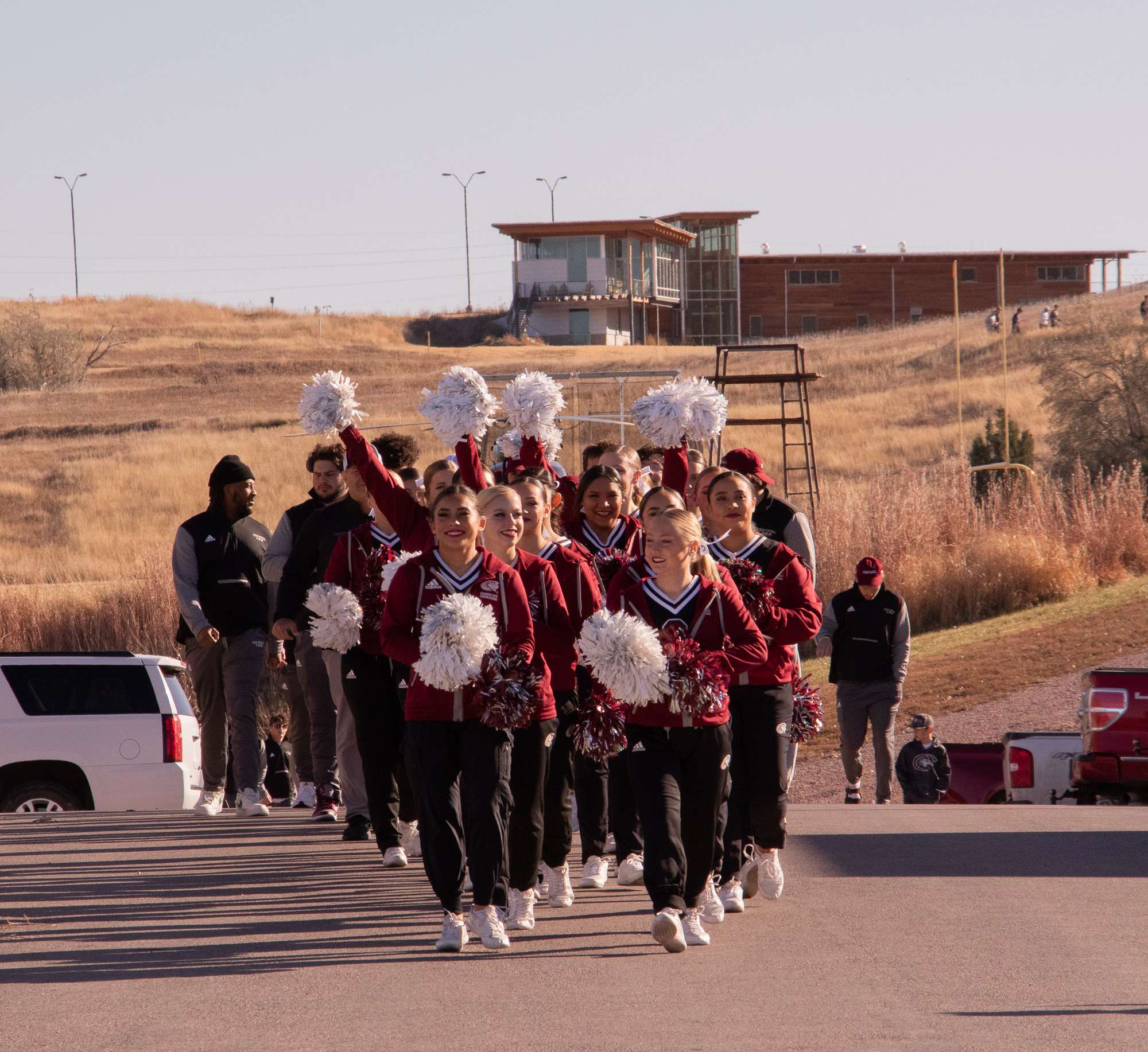 The Chadron State College cheer team leads the Eagle Walk, a parade of football team members south of the Chicoine Center, before the game against South Dakota School of Mines and Technology and a Veteran's Day ceremony on Nov. 11, 2023. (Photo by Tena L. Cook/Chadron State College)