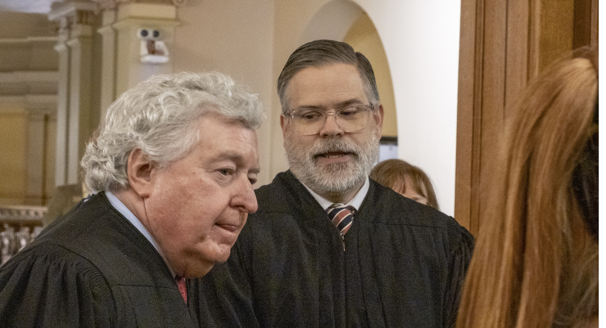 Kansas Supreme Court Justice Caleb Stegall, right, authored the high court's unanimous opinion rejecting arguments by Capitol Federal Savings Bank, headquartered in Topeka, that plaintiffs shouldn't be allowed to pursue a lawsuit claiming the bank's customer contract didn't clearly outline rules on overdraft fees. The Supreme Court affirmed a decision by the Kansas Court Appeals against Capitol Federal, which sends the case back to Shawnee County District Court. In this image from Jan. 15, 2025, Stegall is with Supreme Court Justice Dan Biles. (Photo by Sherman Smith/Kansas Reflector)