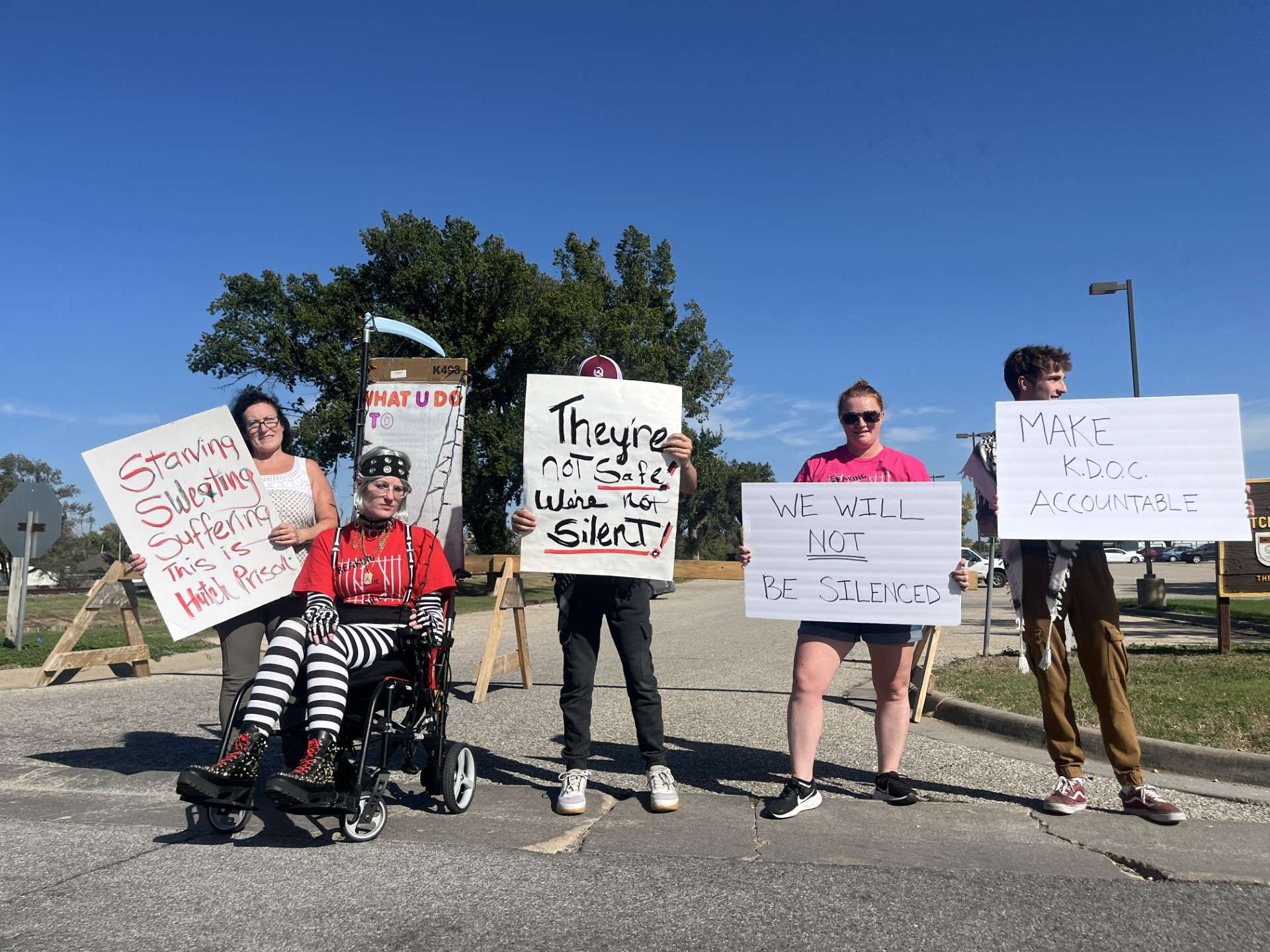 Protestors holding up signs at the Prisoners' Rights Kansas protest on October 11 in Hutchinson. Courtesy of Ellen Johnson
