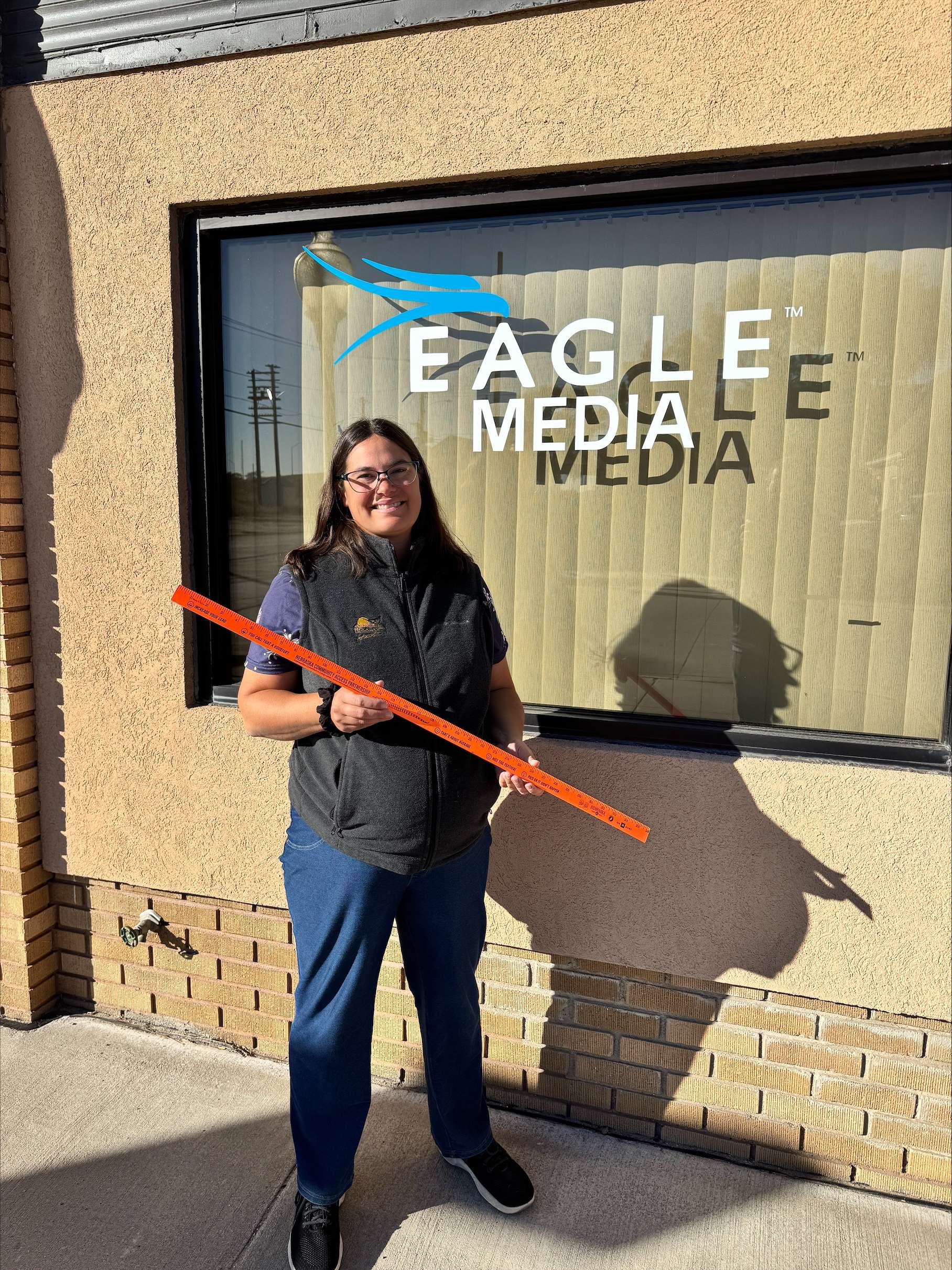 Addie Piernicky holds a yardstick while explaining the Longest Tail Feather Competition, encouraging hunters to participate on newly enrolled public access lands.