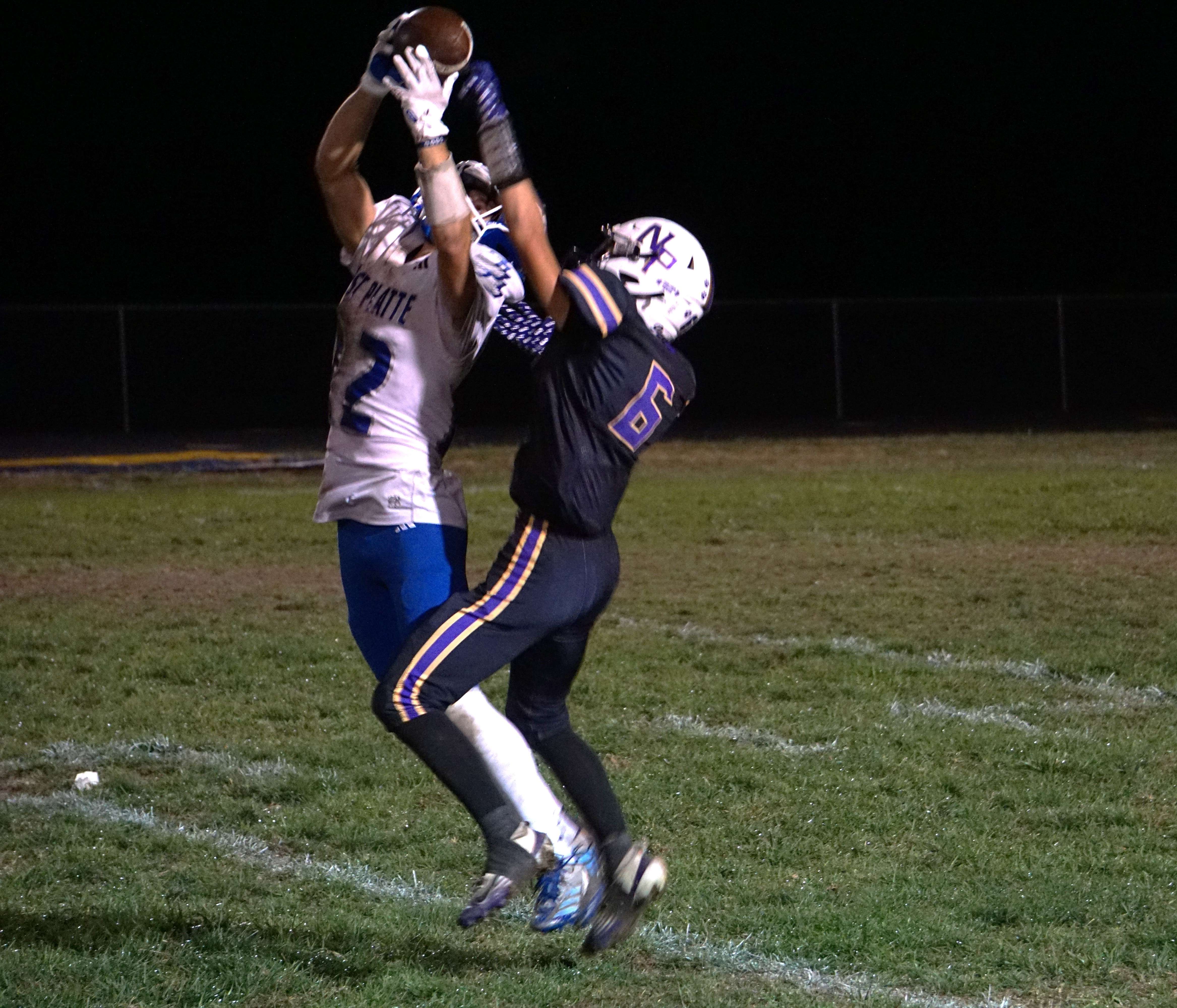 West Platte's Macklin Bolling (12) leaps and hauls in a contested catch against North Platte's Hudson Yarc (6)/ Photo by Matt Pike
