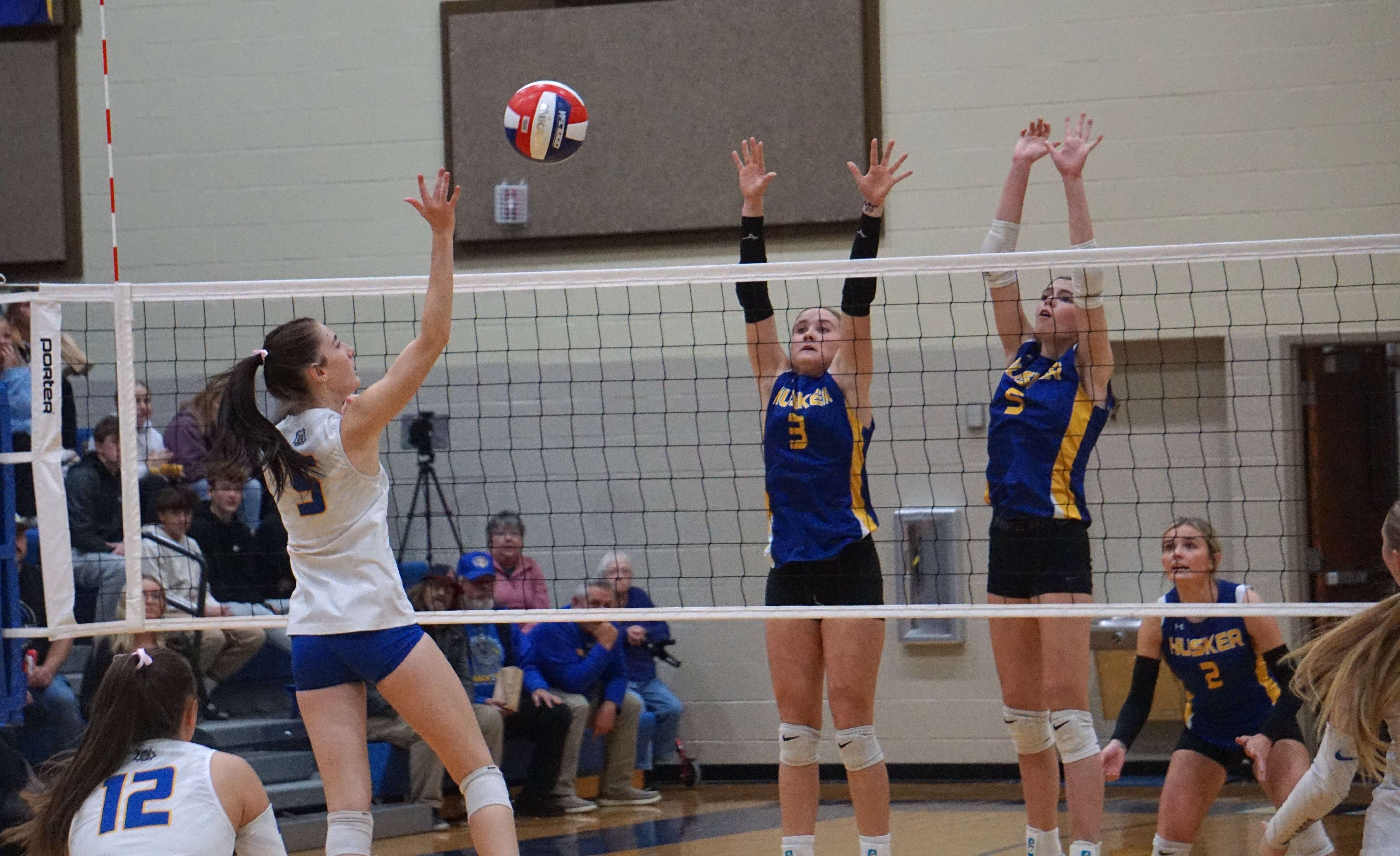 East Buchanan's Kamryn Werle (5) lays the ball over the wall of Lafayette County's Chloe Tyler (3) and Claire Frank (5)/ Photo by Matt Pike