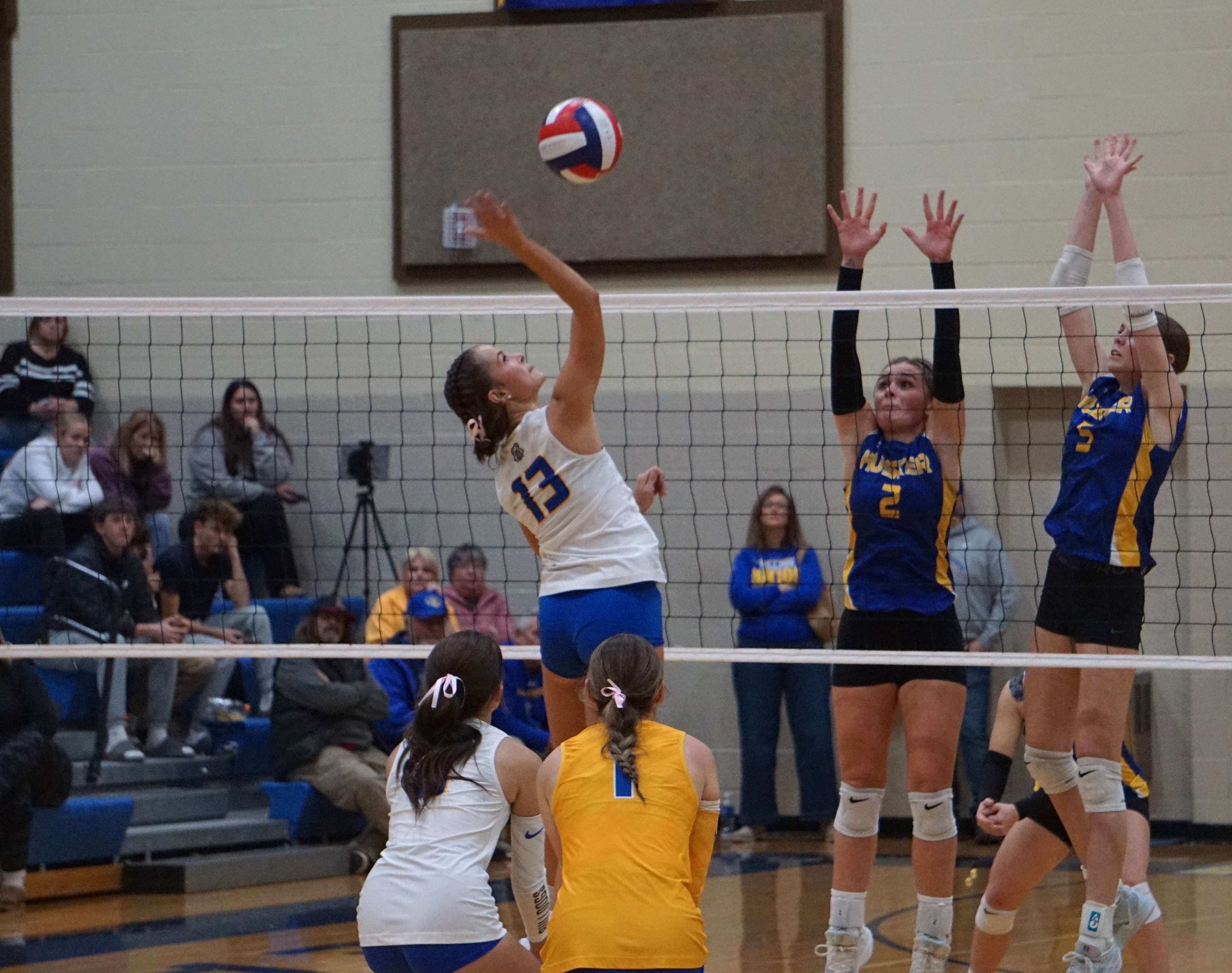 Layla Watkins (13) goes for the spike against Lafayette County's Katie Draisey (2) and Claire Frank (5)/ Photo by Matt Pike