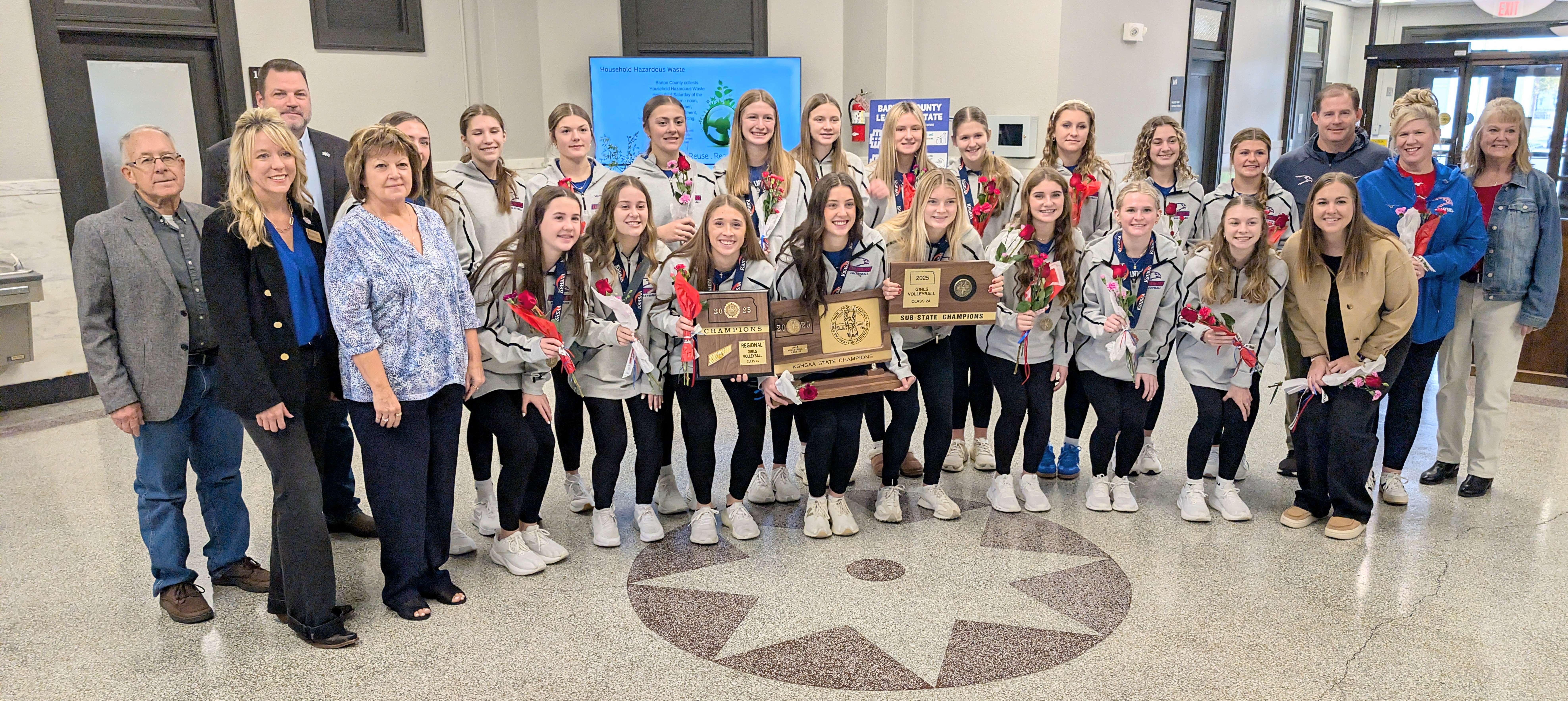 Pictured are: Members of the Ellinwood High School girls’ volleyball team Lexi Thomas, Bennett Jacobs, Reagan Stickney, Regan Widener, McKena Parker, Kyndal Moore, Mallory Batchman, Alyvia Batchman, Blayre Moore, Kenna Stickney, Avery Panning, Reece Stickney, Mette Maxwell, Addie Stickney, Paisley Knop, Reagan Wirtz, Ayla Ritchie, Brynn Widener and Jaizley Andrasek; coach Coach Greg Maxwell and assistant coaches Cami Thomas and Becca Maxwell; and Barton County Commissioners Don Reif, Tricia Schlessiger, Shawn Hutchinson, Donna Zimmerman and Barb Esfeld. The commissioners had just honored the team for its state volleyball championship.