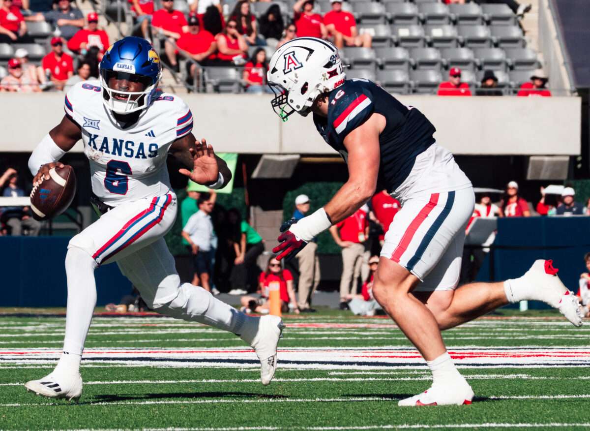 Kansas quarterback Jalon Daniels scrambles away from Arizona linebacker Riley Wilson on Saturday, Nov. 8, 2025, in Tucson, Ariz. (Photo courtesy Kansas Athletics)