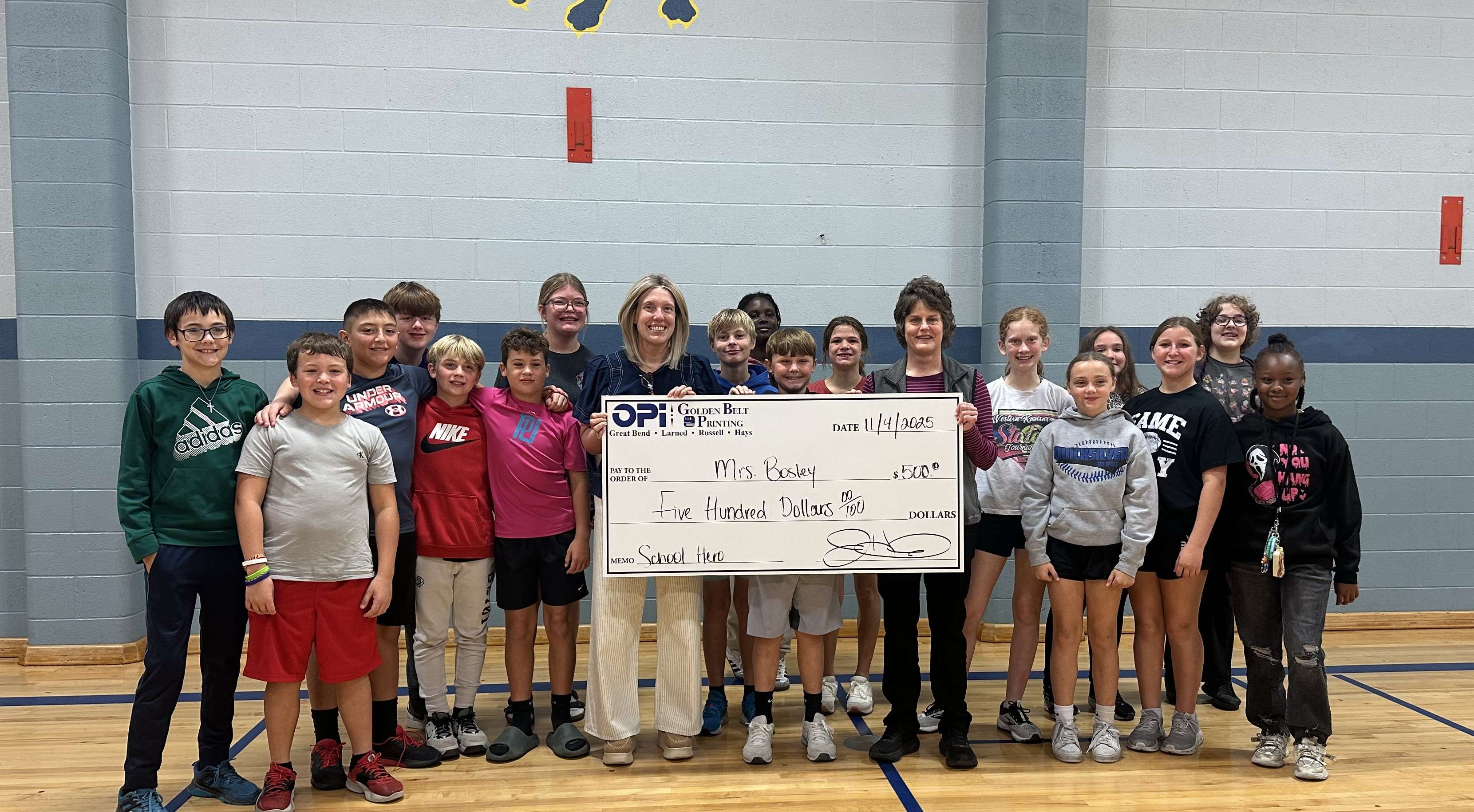 Tina Koochel with OPI & Golden Belt Printing presents Lincoln Elementary teacher Jennifer Bosley and her sixth-grade students with a $500 check as the October winner in the Nominate a School Hero Contest.