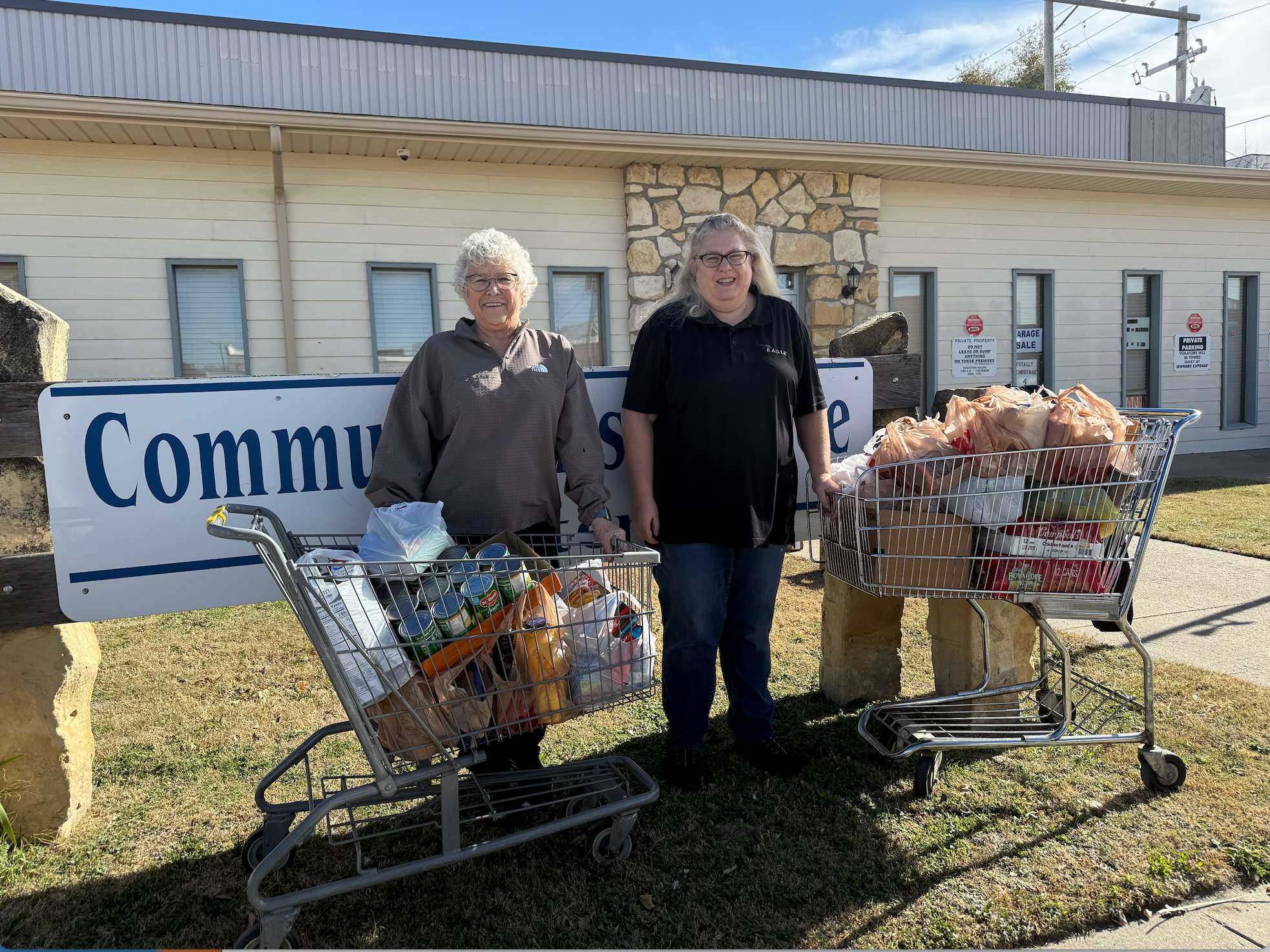 Cristina Janney, Hays Post editor, right, delivers food to Patty Rupp, left, of the Community Assistance Center on Tuesday following the first day of the Hays Post Food Drive.
