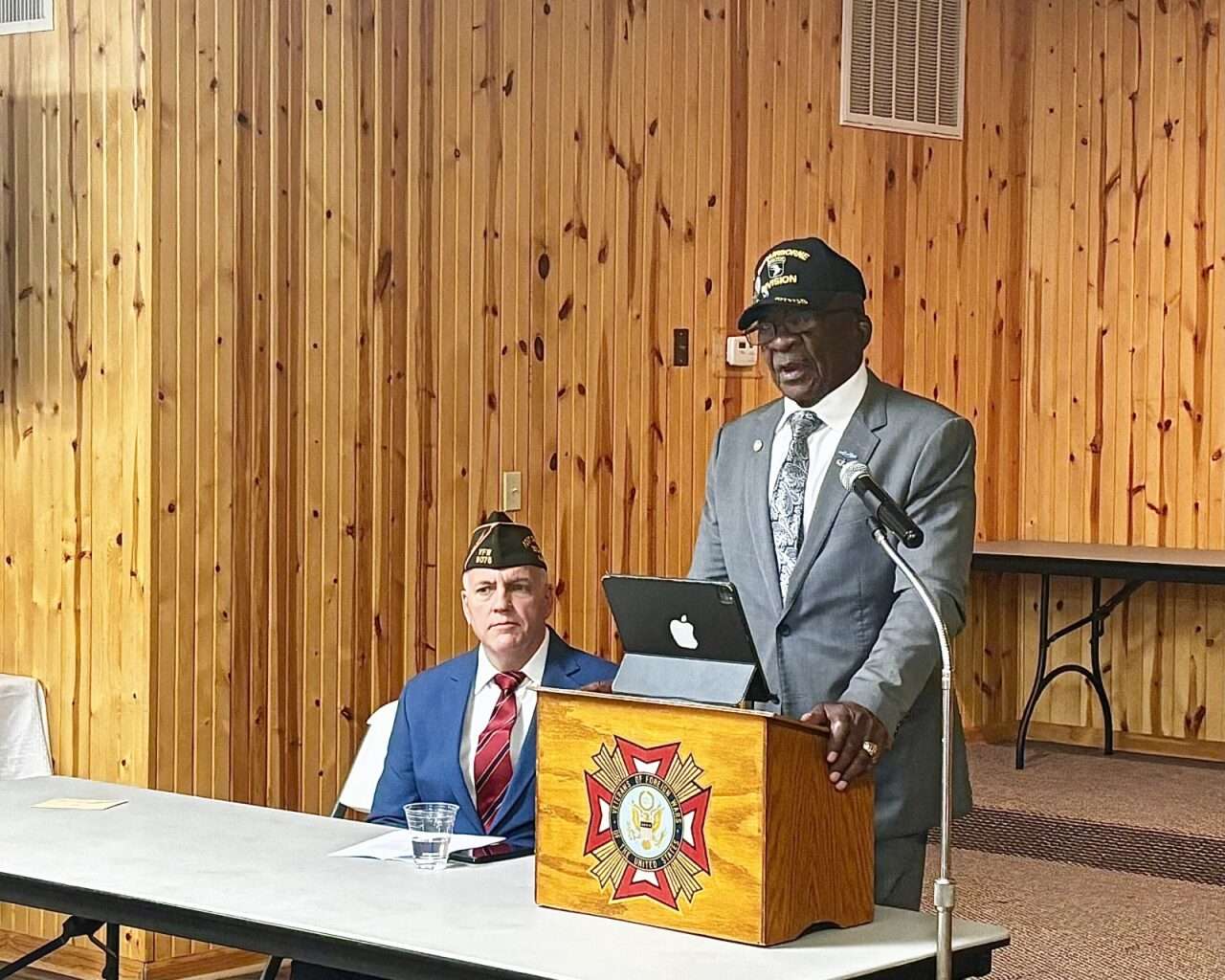 Retired Command Sgt. Maj. Ivanhoe Love speaking at the Hays VFW, standing next to Mike Morley, commander of VFW Post 9076. Photo by Tony Guerrero/Hays Post