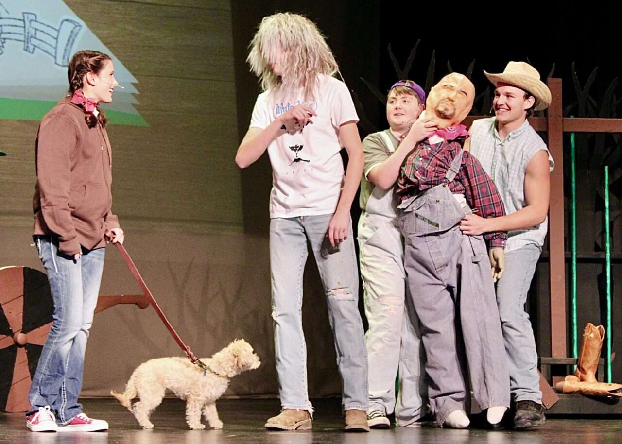 Grace Schmeidler as Dorothy Gale with several supporting characters and Toto on stage for "The Wizard of Oz" production.&nbsp;