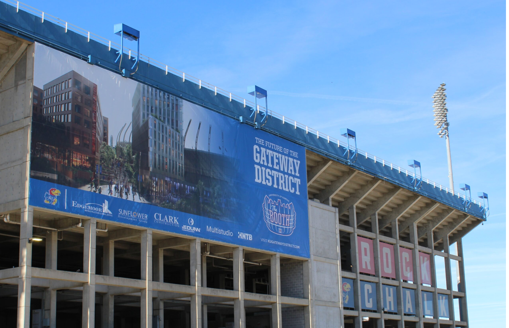 A banner hangs on the untouched portion of the University of Kansas football stadium in Lawrence, Kansas, on Nov. 12, 2025. It depicts a rendering of upcoming plans to complete stadium renovations and construct a hotel and parking garage, creating what will be known as the Gateway District. (Photo by Anna Kaminski/Kansas Reflector)